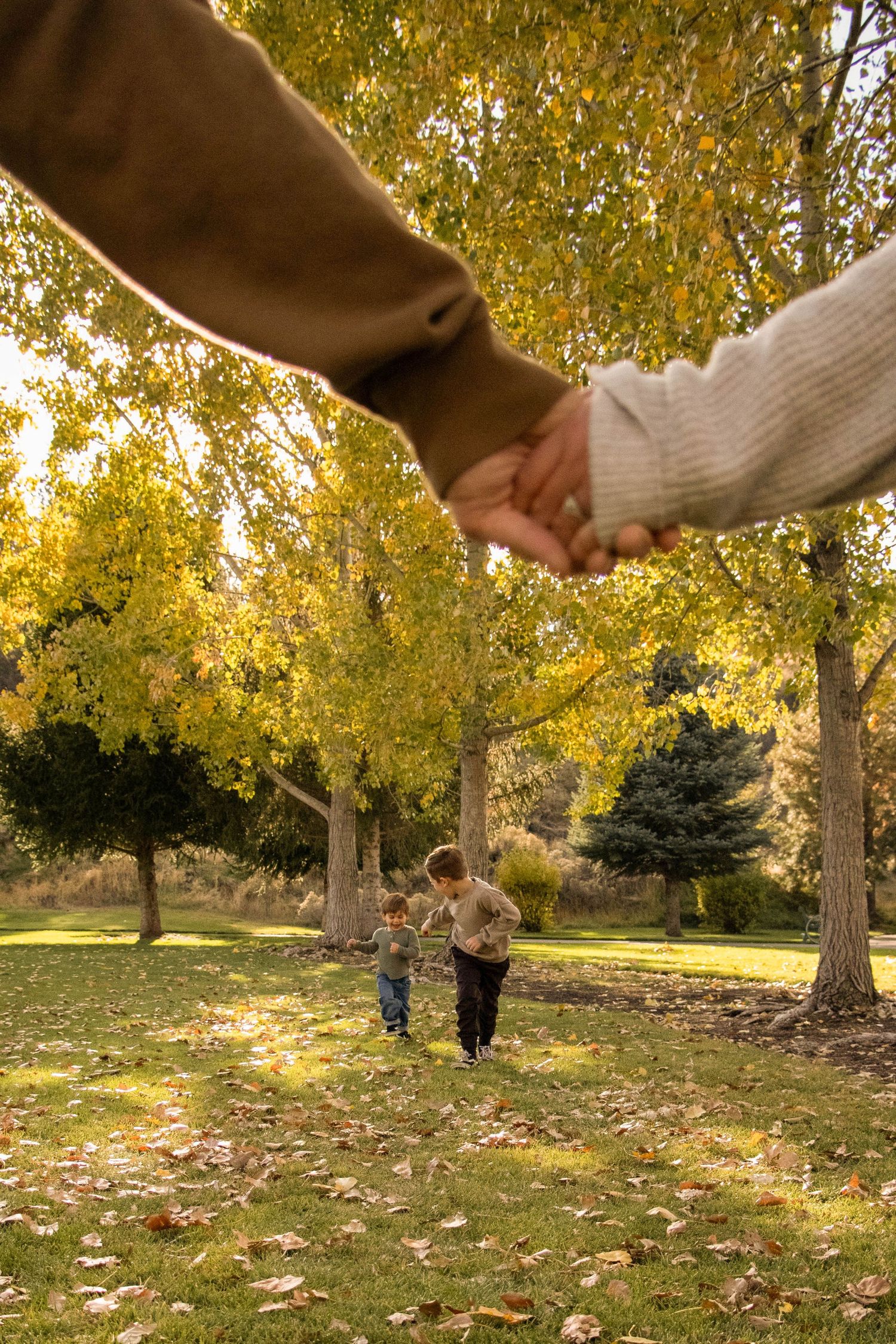 two sons run toward their mom and dad in a Bend, Oregon park