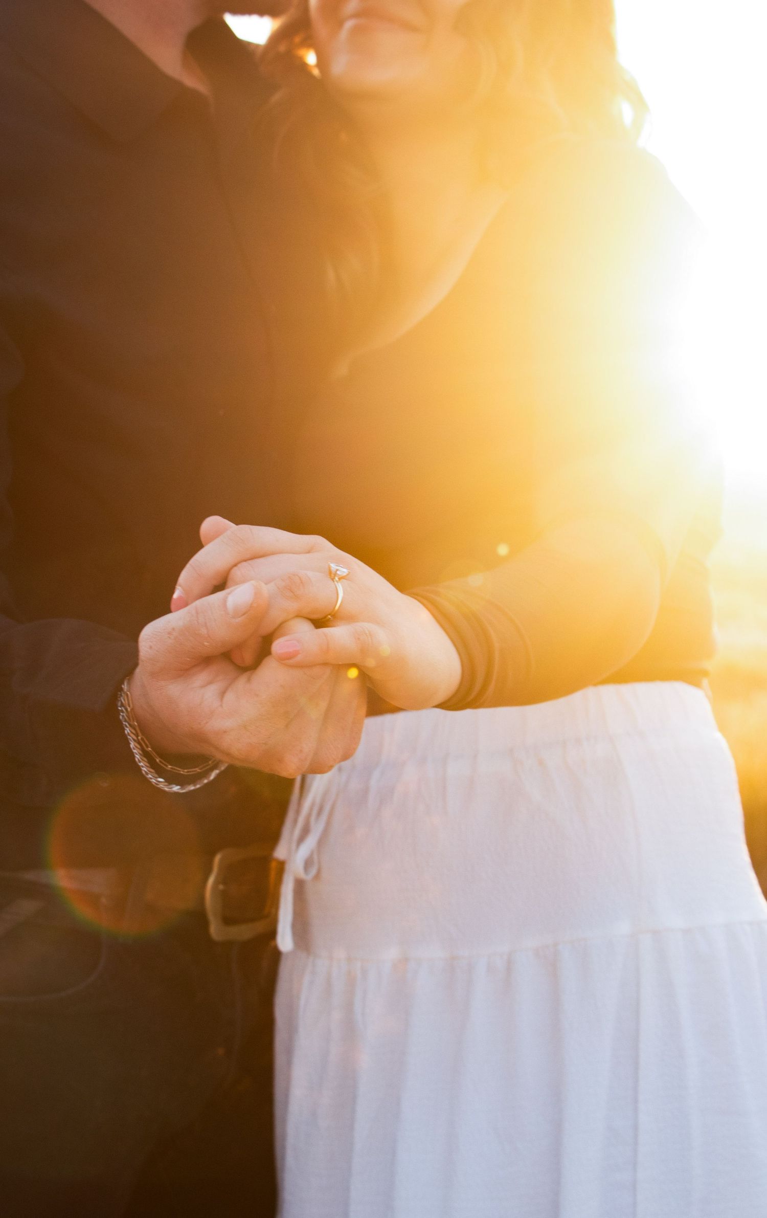 a couple holds hands at the Central Oregon sun shines on them