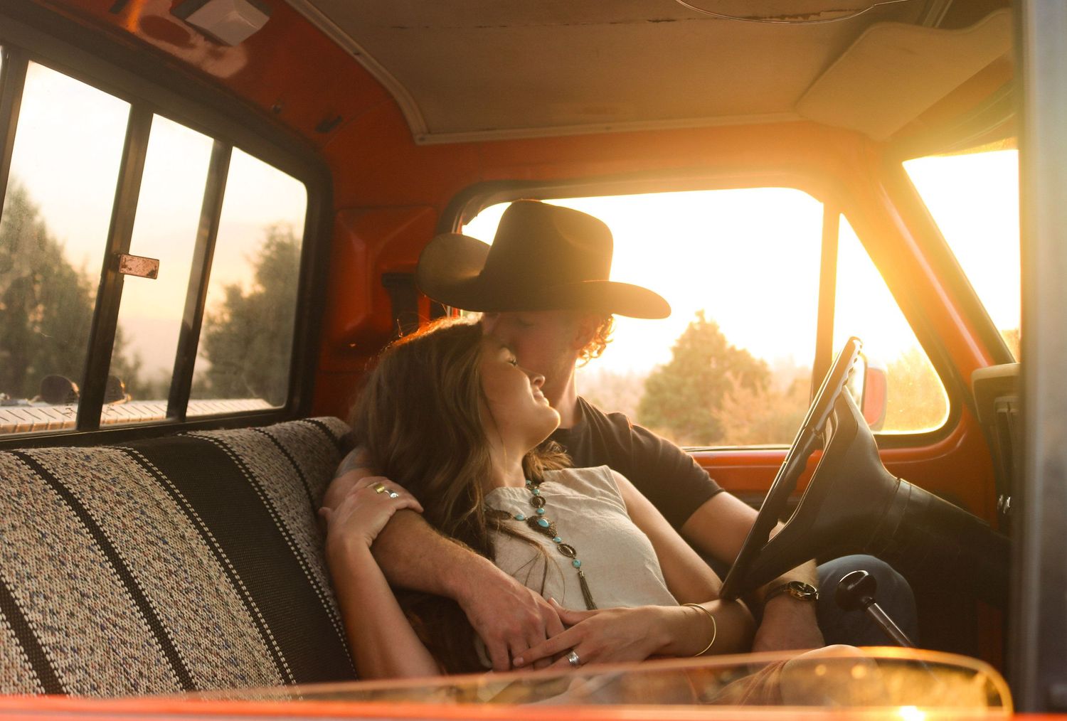 a couple sits close to each other in a vintage truck
