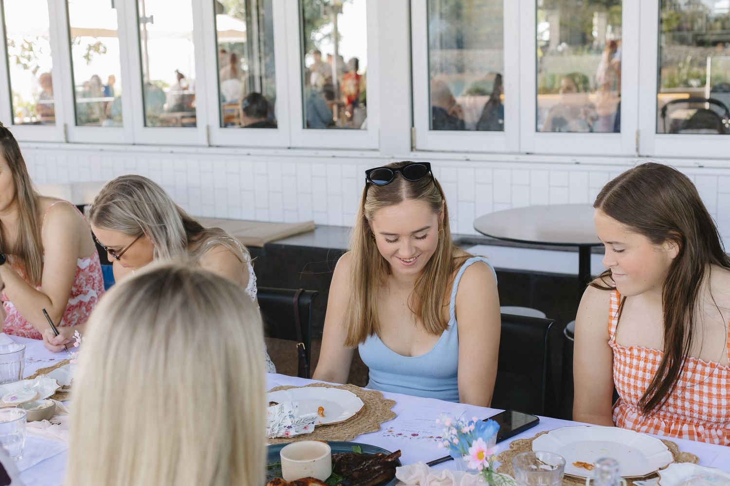 Guests seated at decorated tables during a daytime outdoor party.