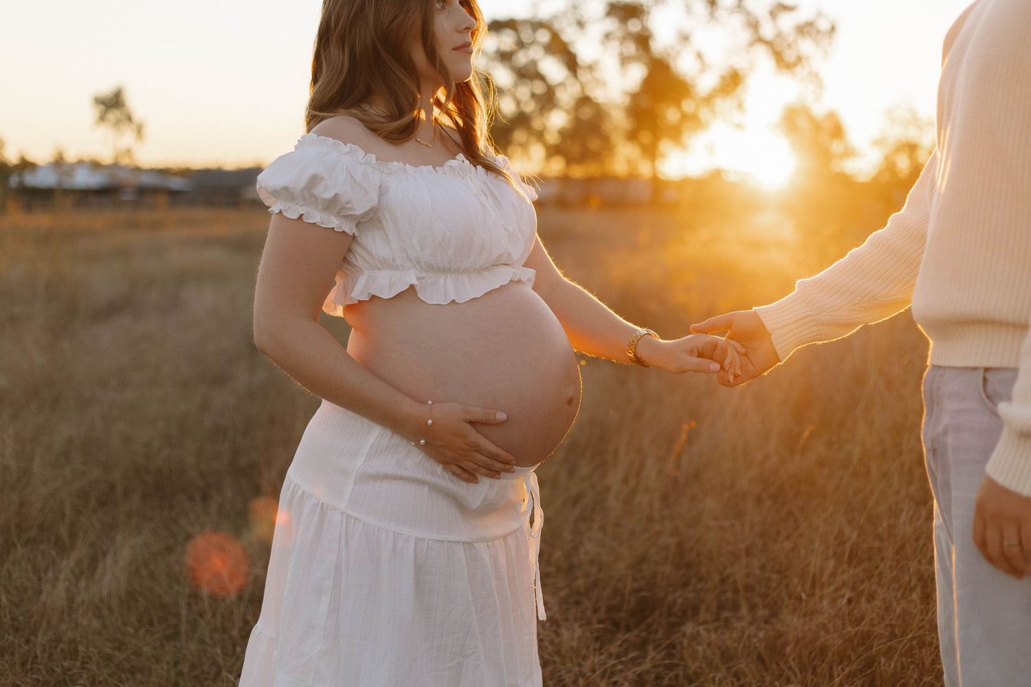 A sunset maternity session capturing silhouettes against golden light.