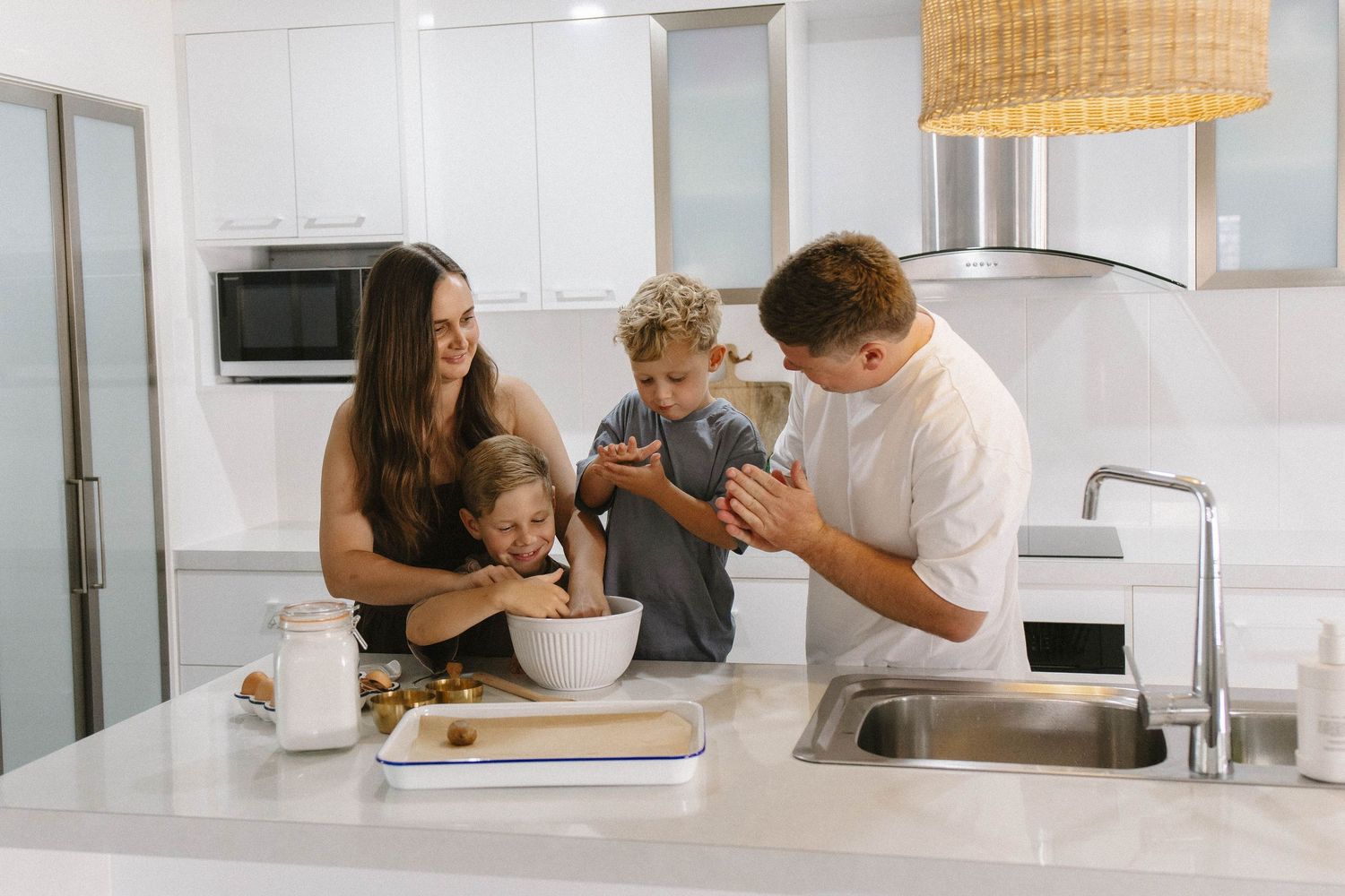 Modern bright kitchen interior with people gathered around counter.