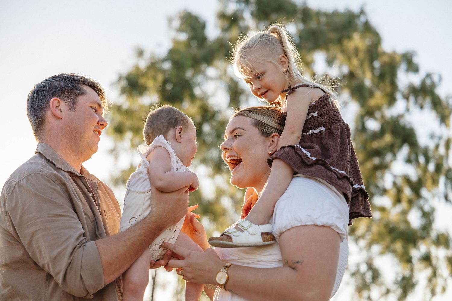 Candid family moments captured during golden hour in a natural outdoor setting.