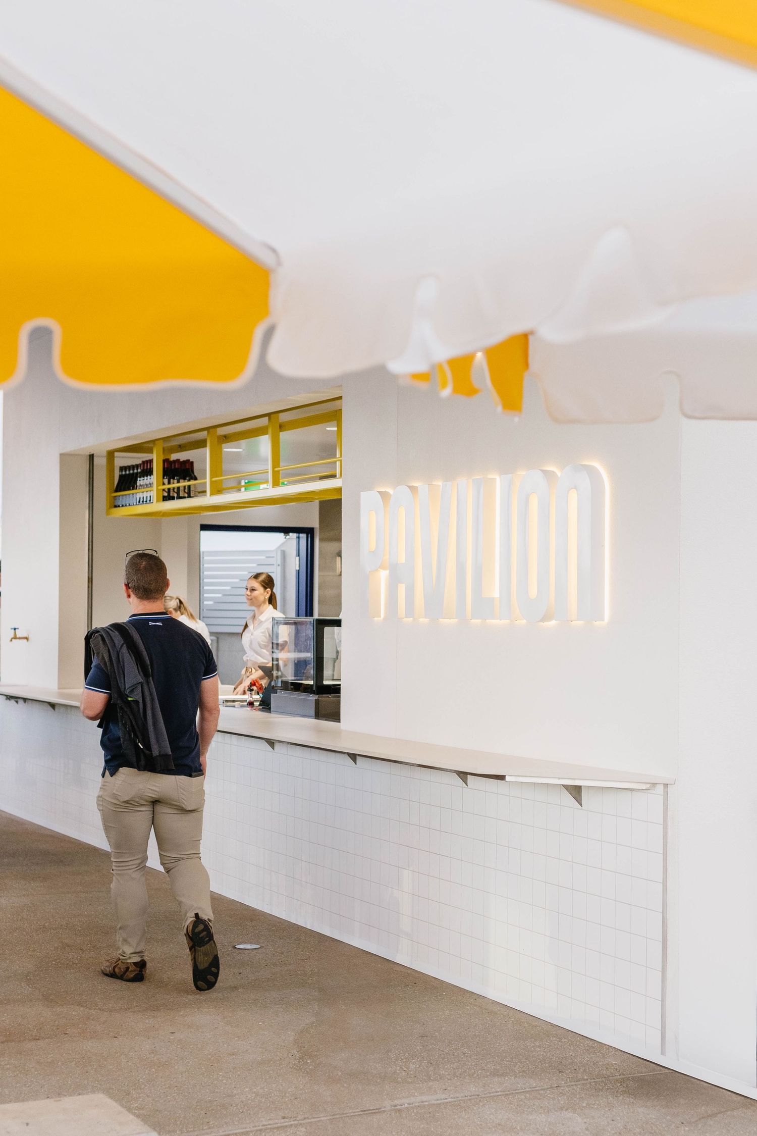 Modern white service counter area with bright yellow accents and minimalist design.