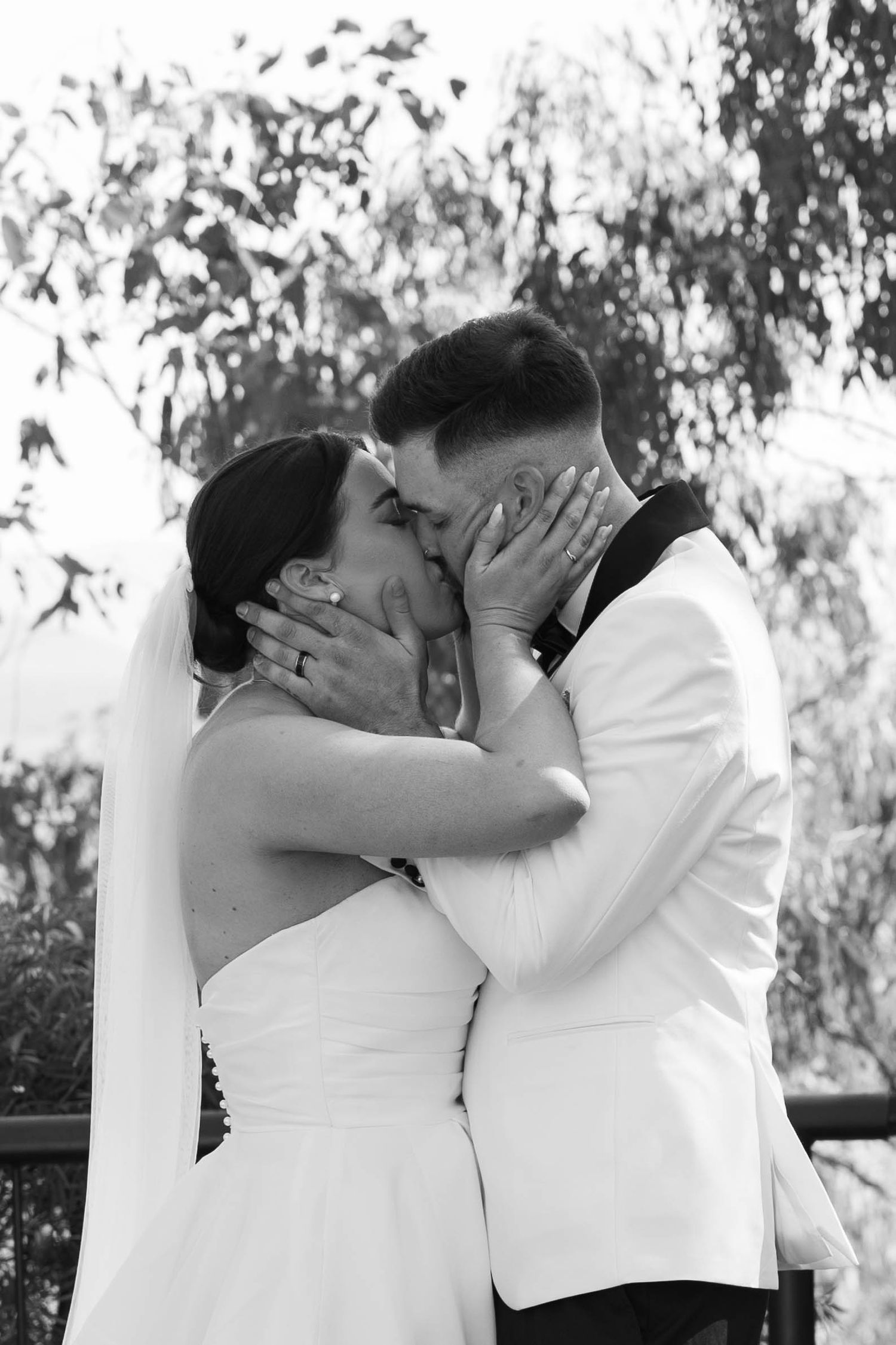 Intimate black and white wedding moment captured outdoors.