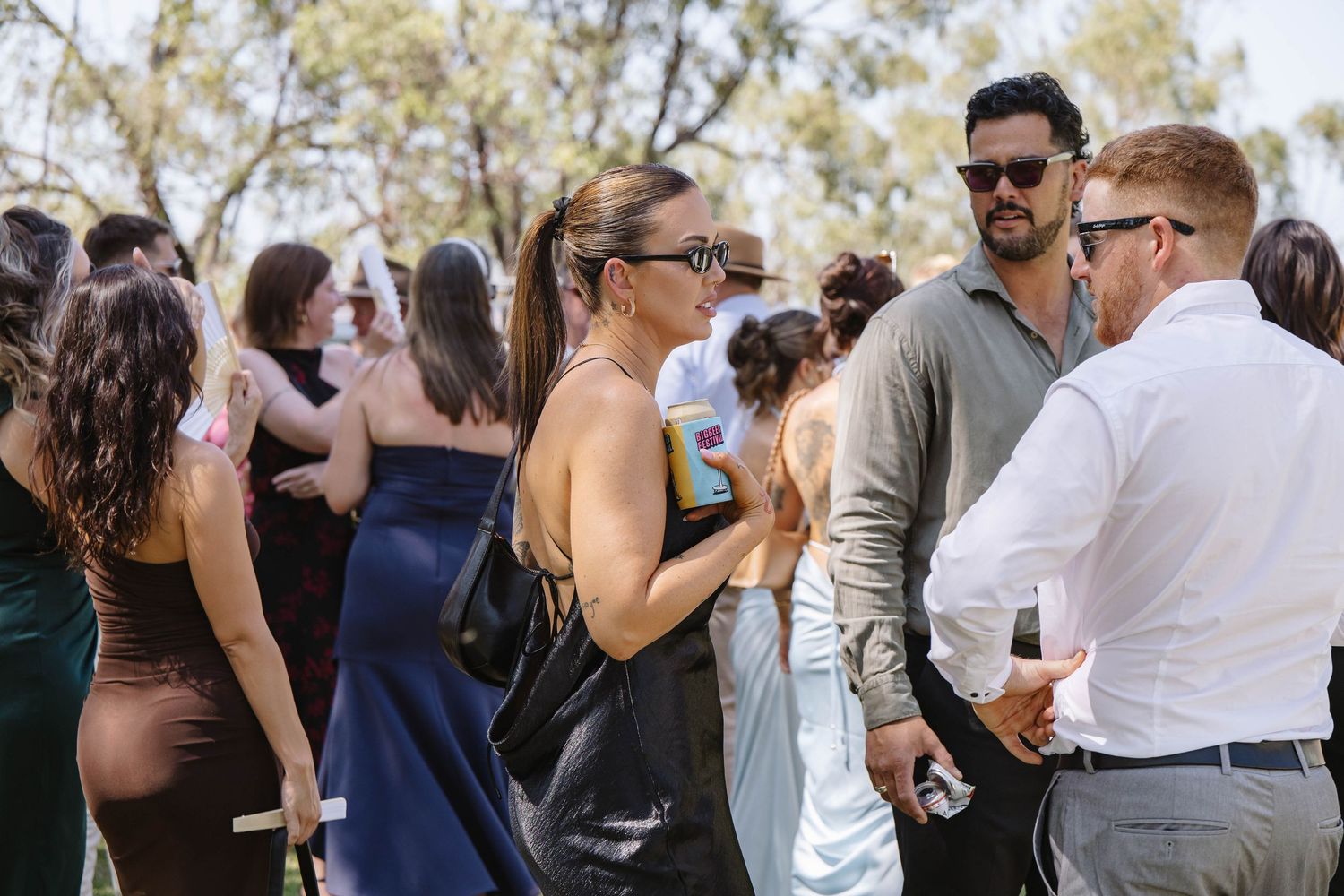 Wedding guests mingling and socializing at an outdoor reception.