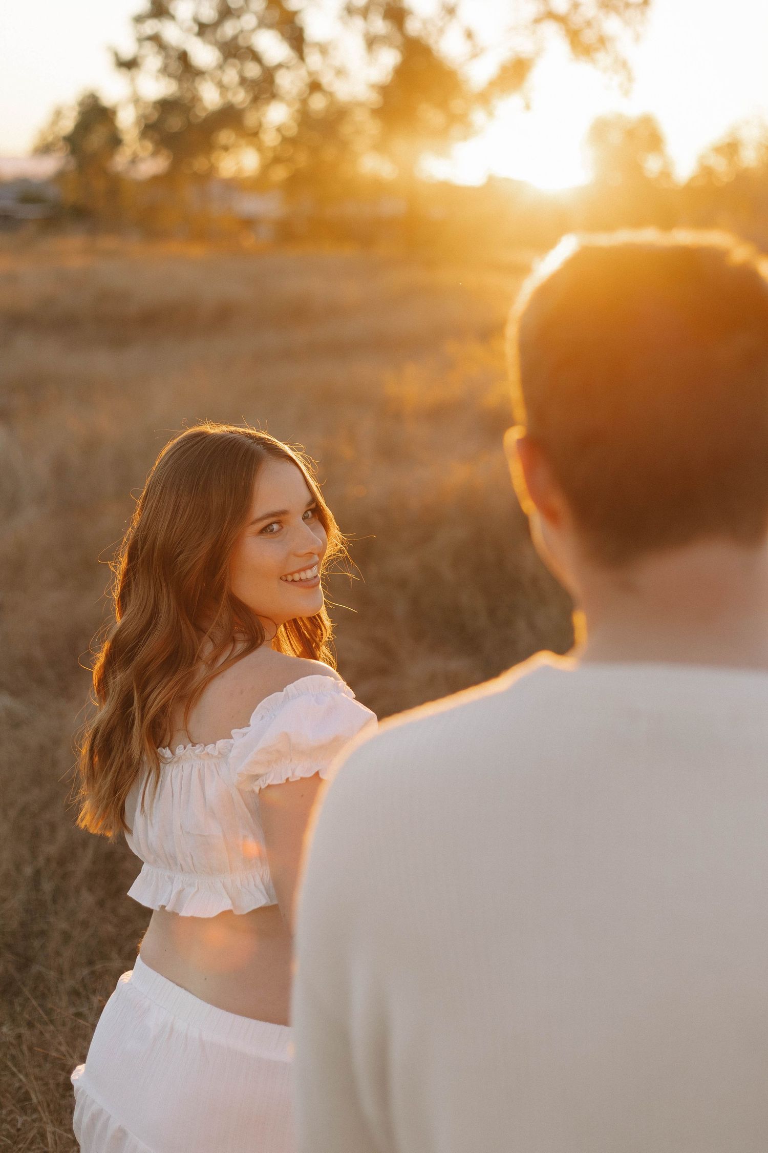 A romantic sunset maternity photo session with warm golden lighting.