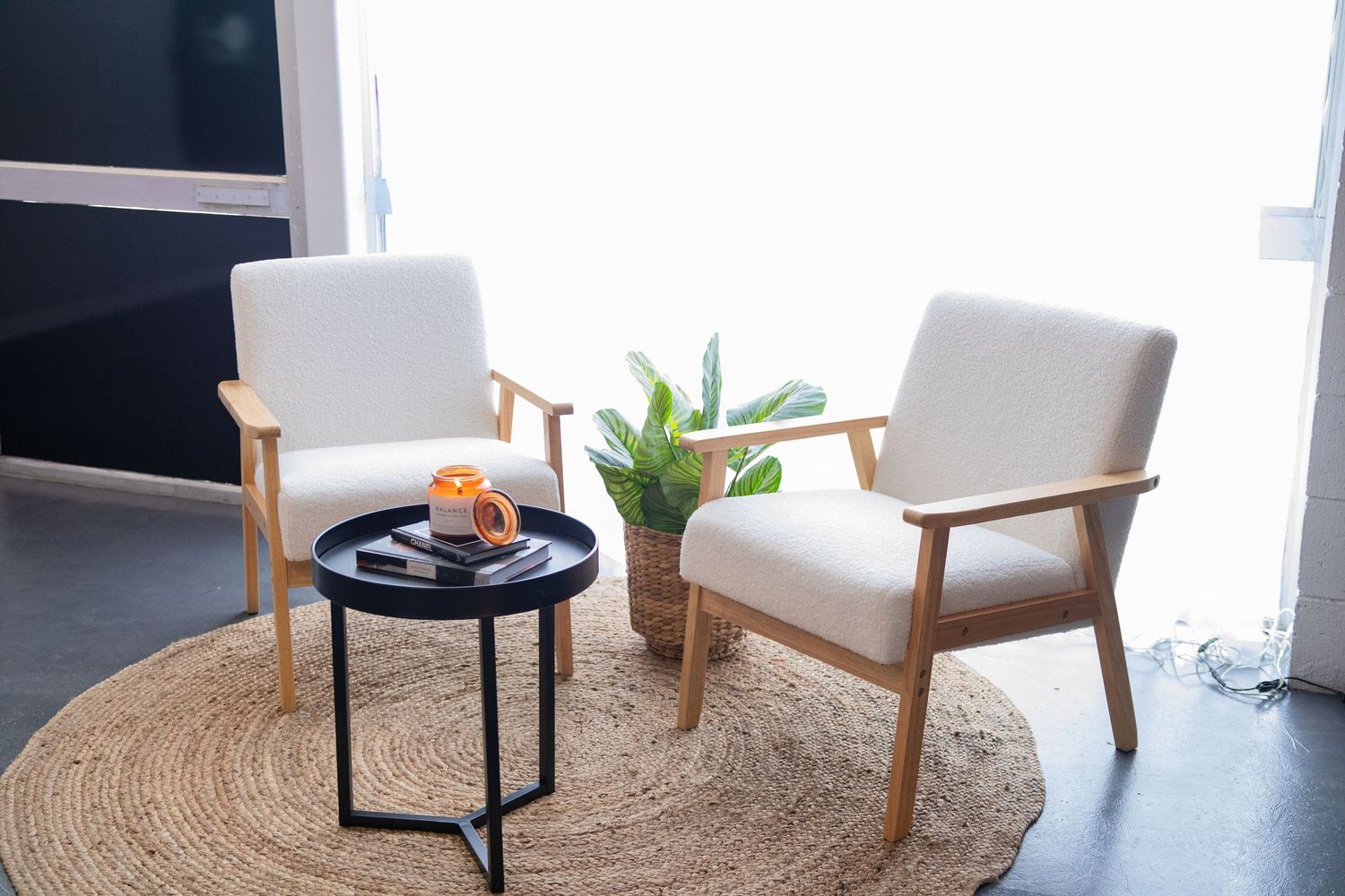 Modern minimalist office interior with white chairs and round jute rug.