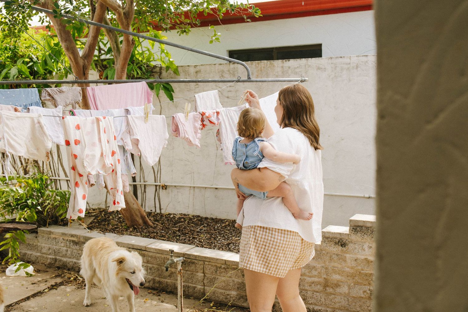Children playing outdoors near decorative pink and white bunting flags on a sunny day.