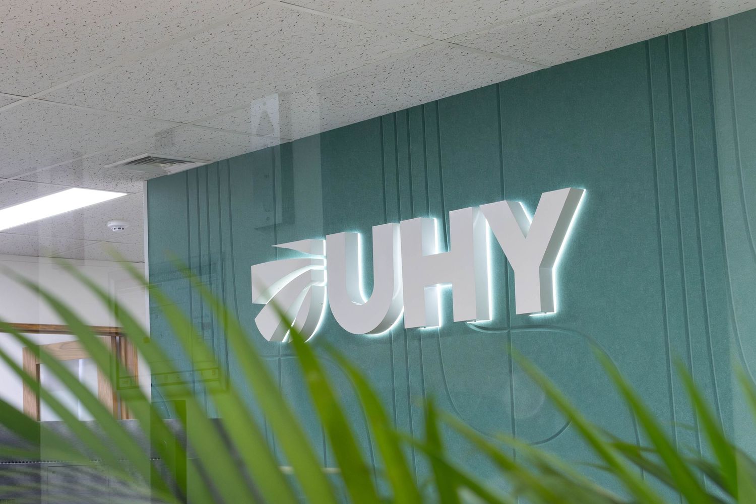 Modern office interior with teal accent wall and decorative text signage.