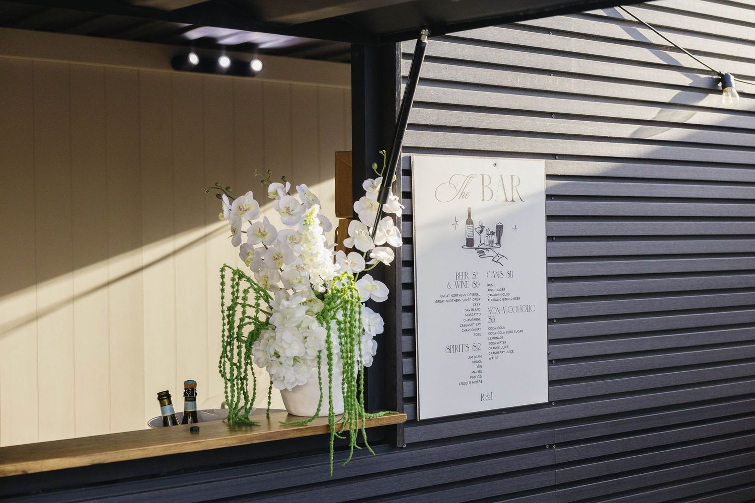 Modern wedding venue exterior with dark horizontal siding and minimalist decor.