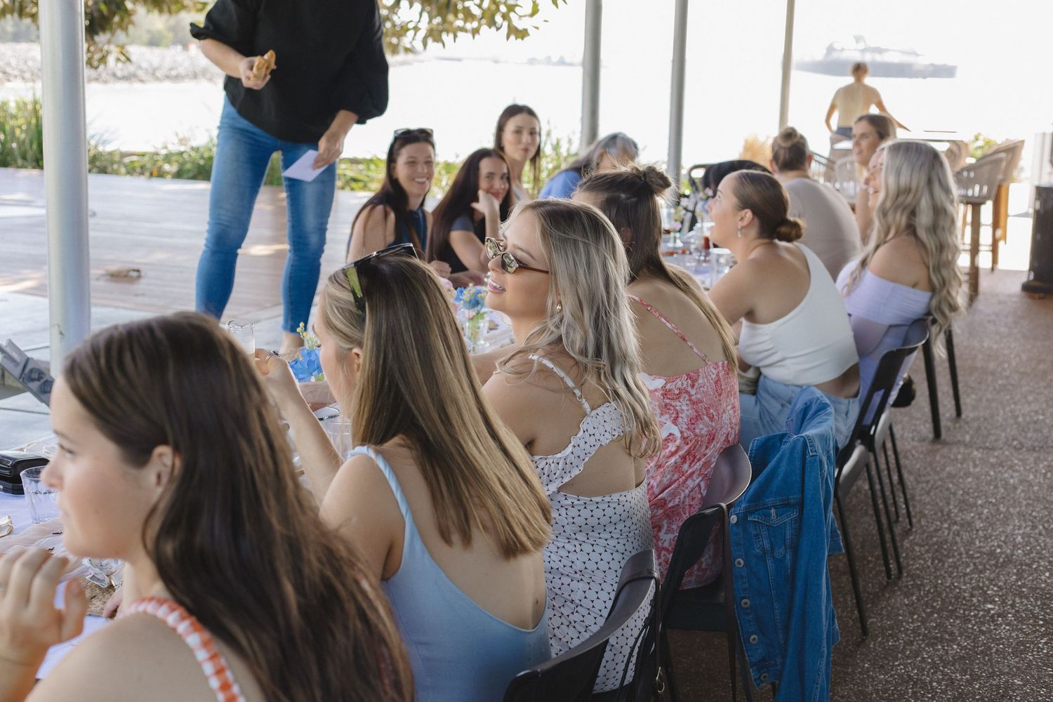 People gathered at long tables for an outdoor social event.
