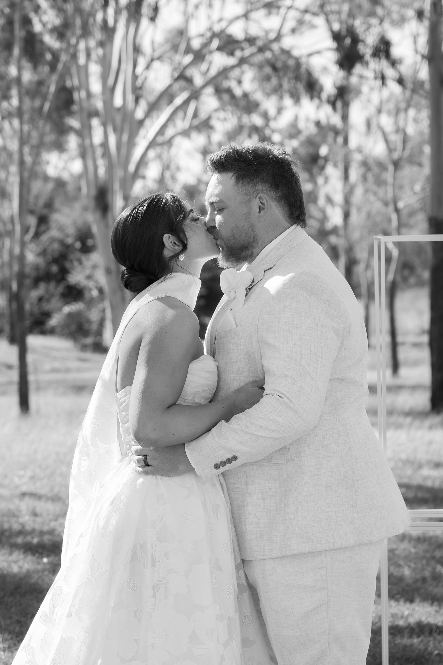 Romantic black and white portraits of newlyweds embracing outdoors.