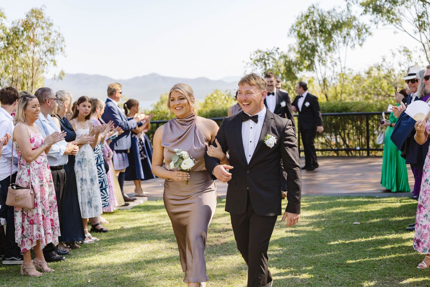 Wedding ceremony taking place at a scenic outdoor venue with mountain views.