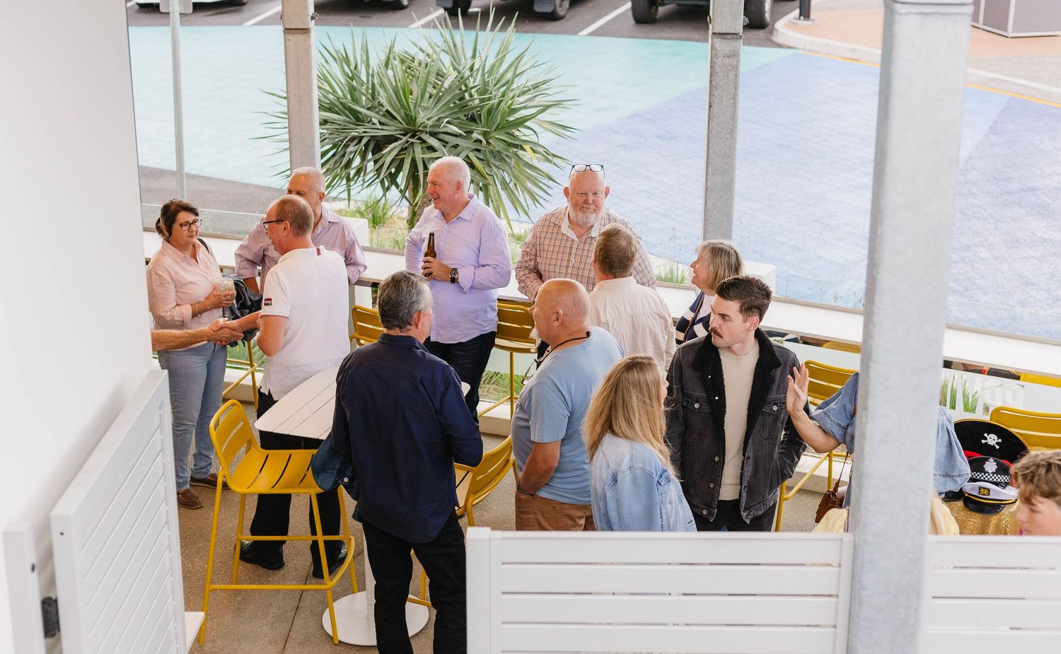 People gathering in a bright modern office space with outdoor views.