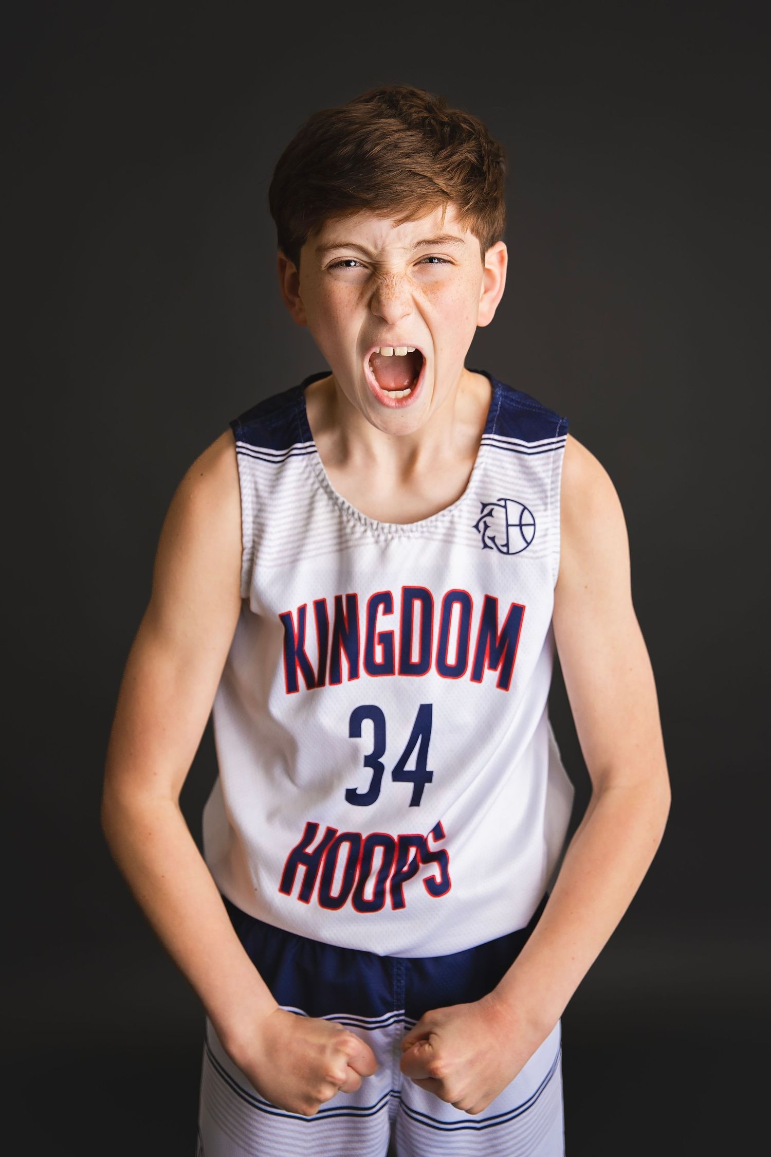 Young boy in Kingdom Hoops number 34 jersey shouting with fists clenched in excitement.