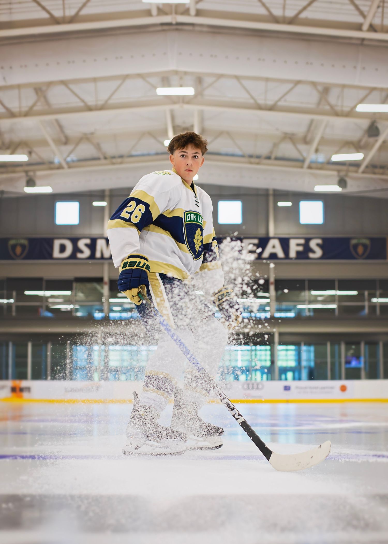 Hockey player #26 sprays ice in dynamic action shot at DSM Leafs arena rink.