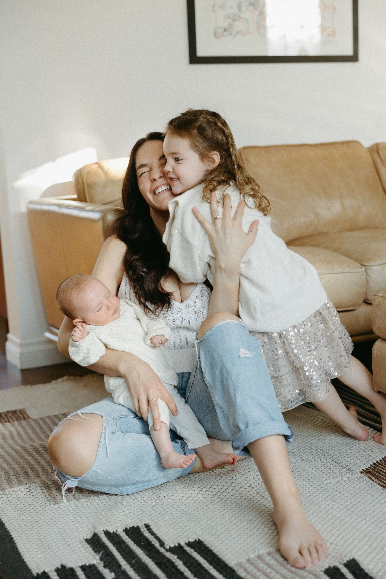 A family shares joyful moments together on a carpeted floor in their living room.