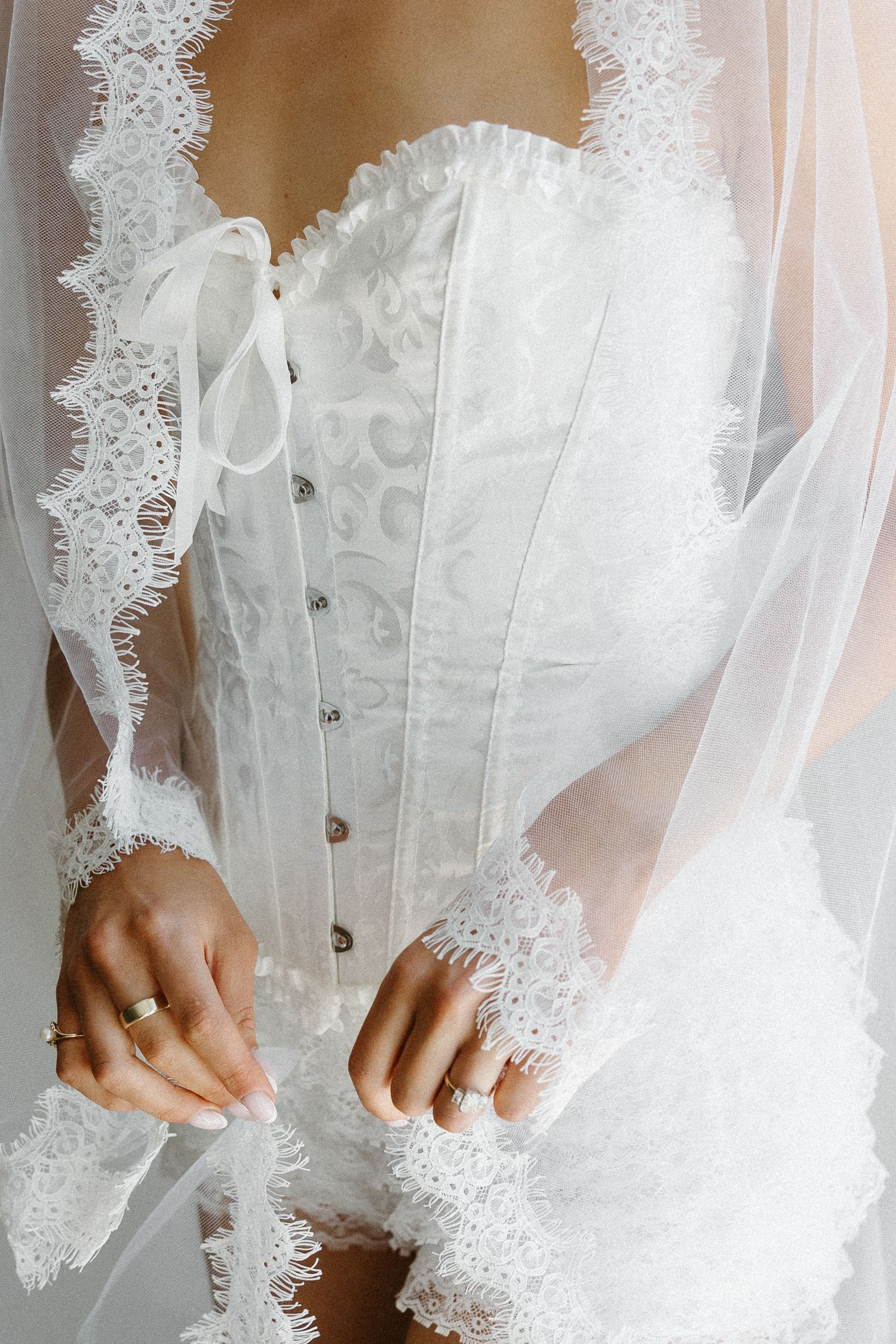 Detail shots of delicate lace wedding dress buttons and fabric textures.