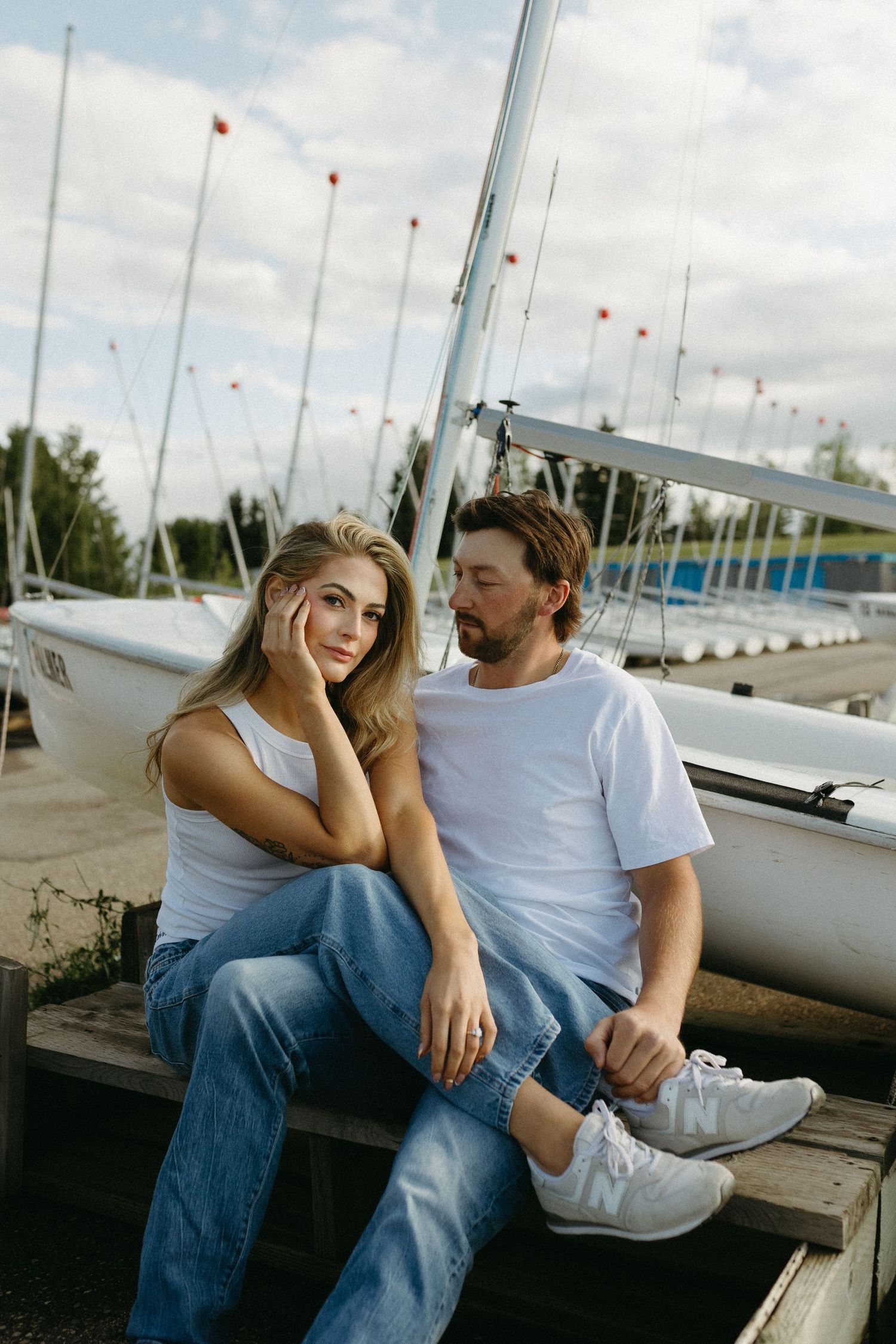 Intimate moment shared on wooden dock with boats and marina scenery.