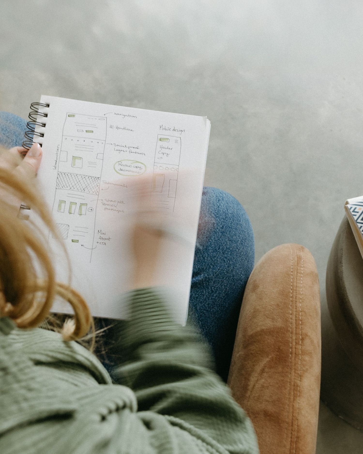 Notebook pages with handwritten notes and sketches laying on a couch.