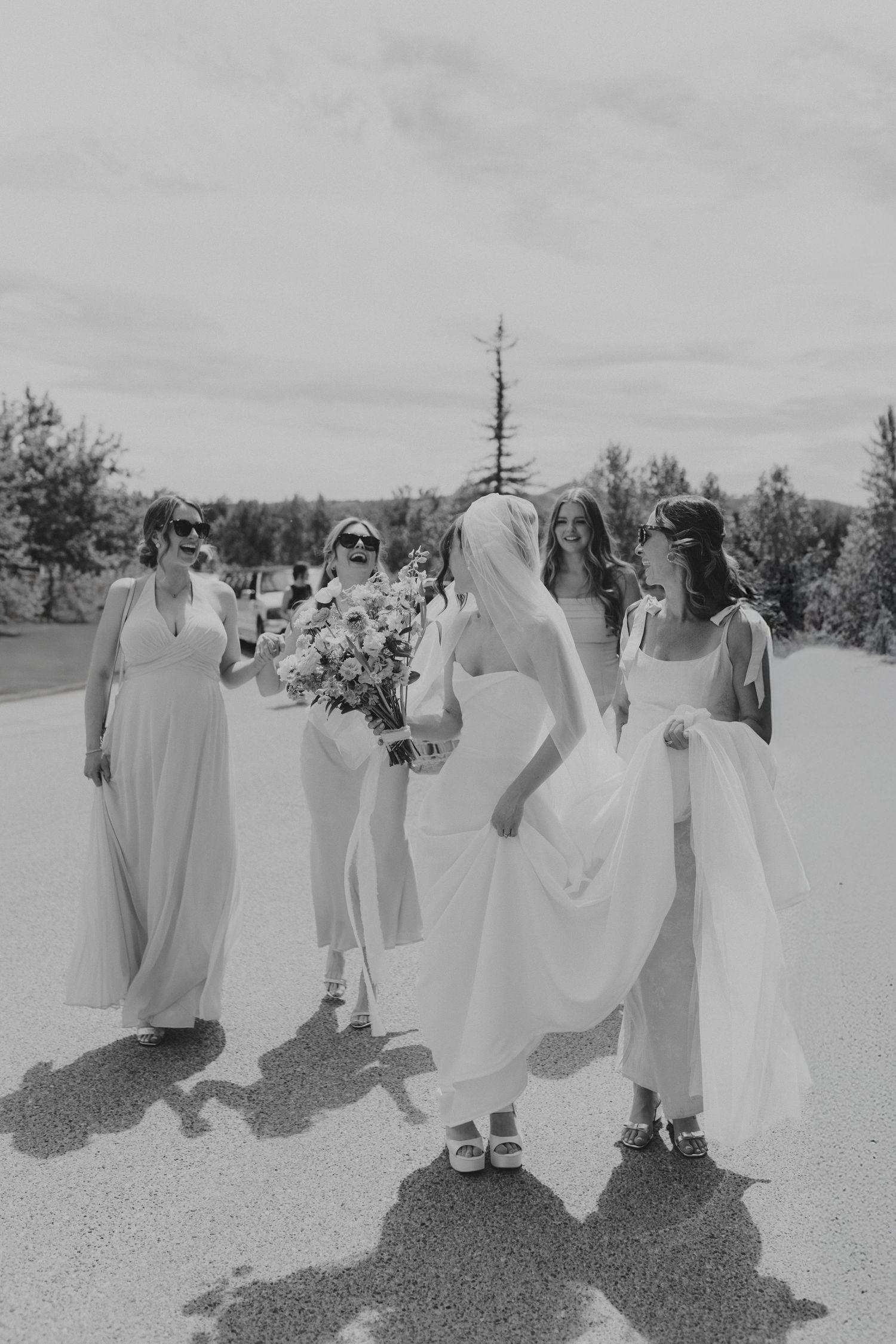Wedding party walking together outdoors in black and white photography.