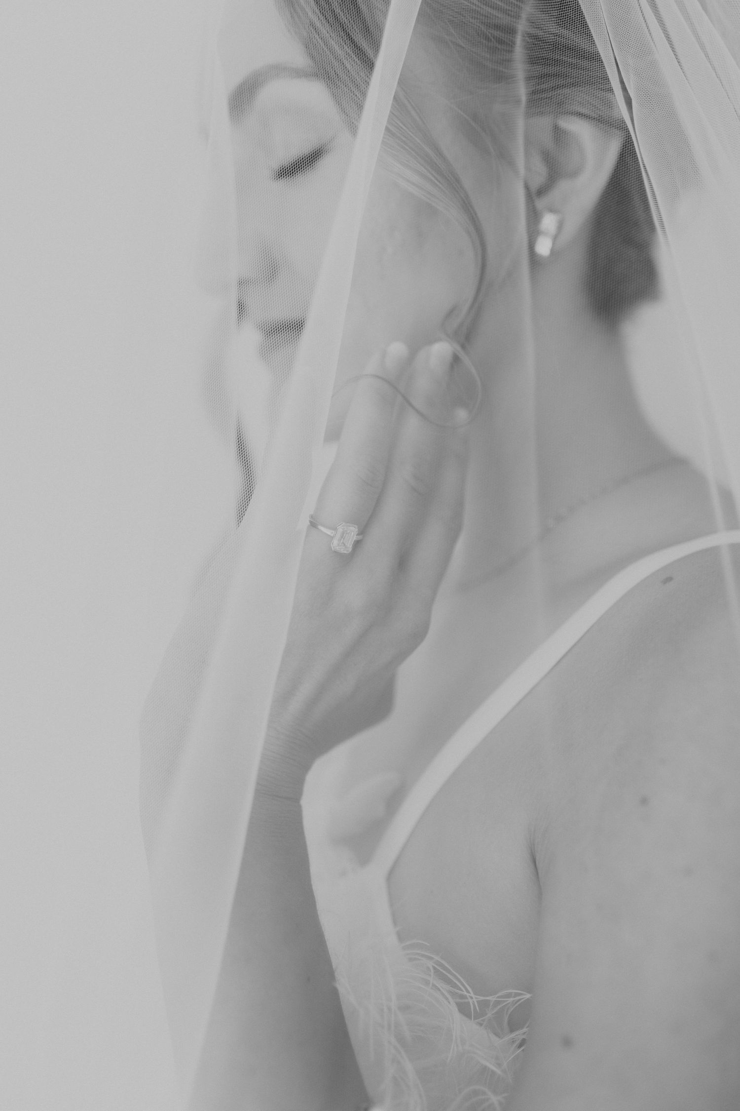 Ethereal side profile of bride with delicate veil in soft focus.
