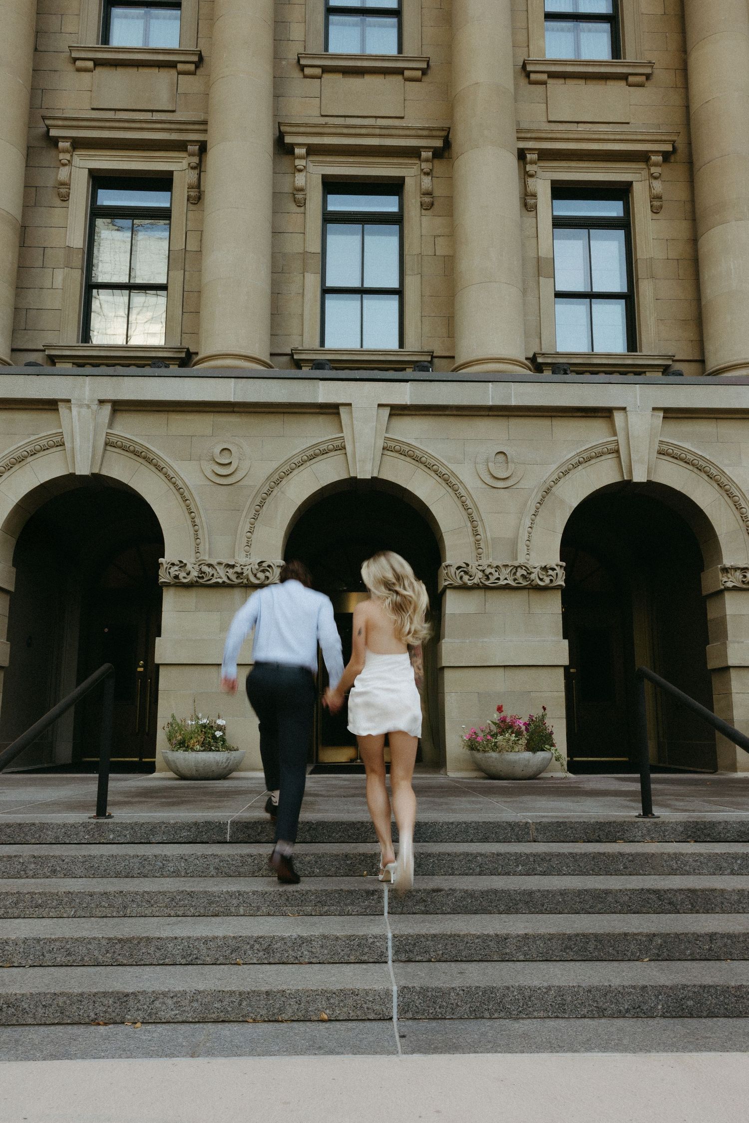 Architectural detail of stone columns and steps at a grand building entrance.