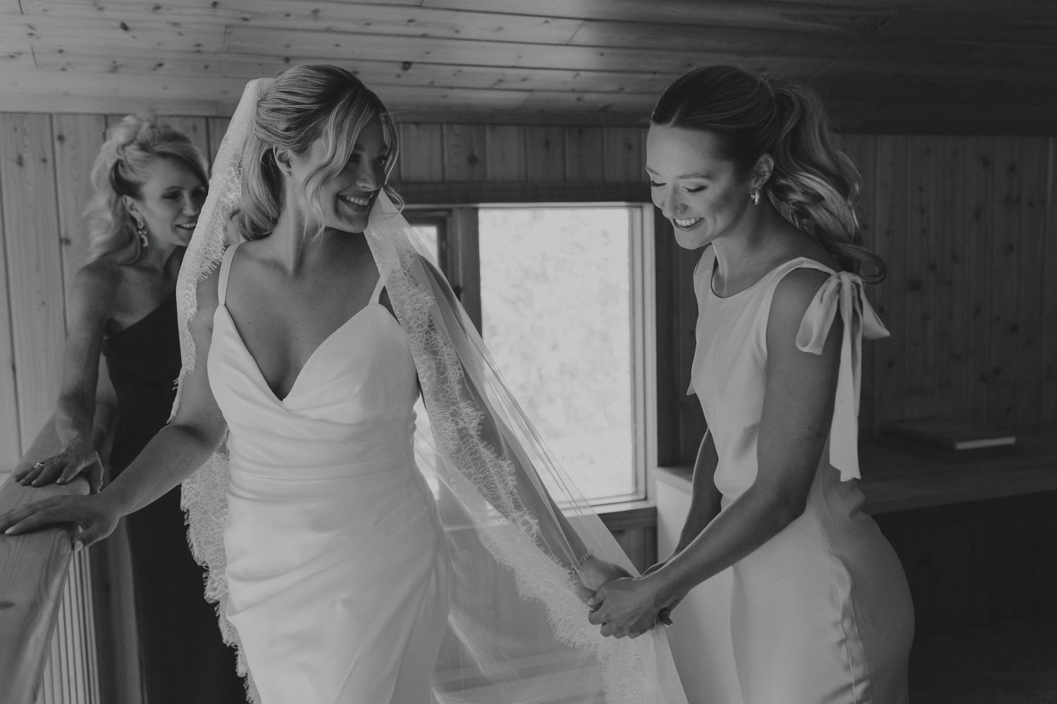 A series of black and white photos showing wedding preparations with a bride getting ready in a rustic wooden setting.