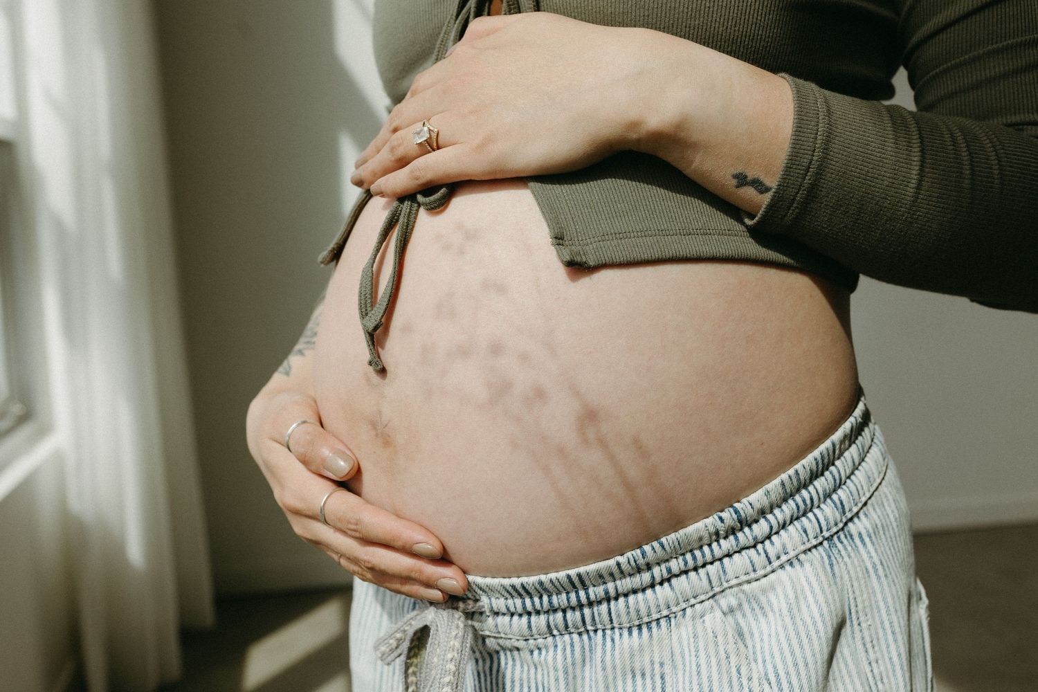 Close-up shots of a pregnant belly being lovingly touched in natural light.