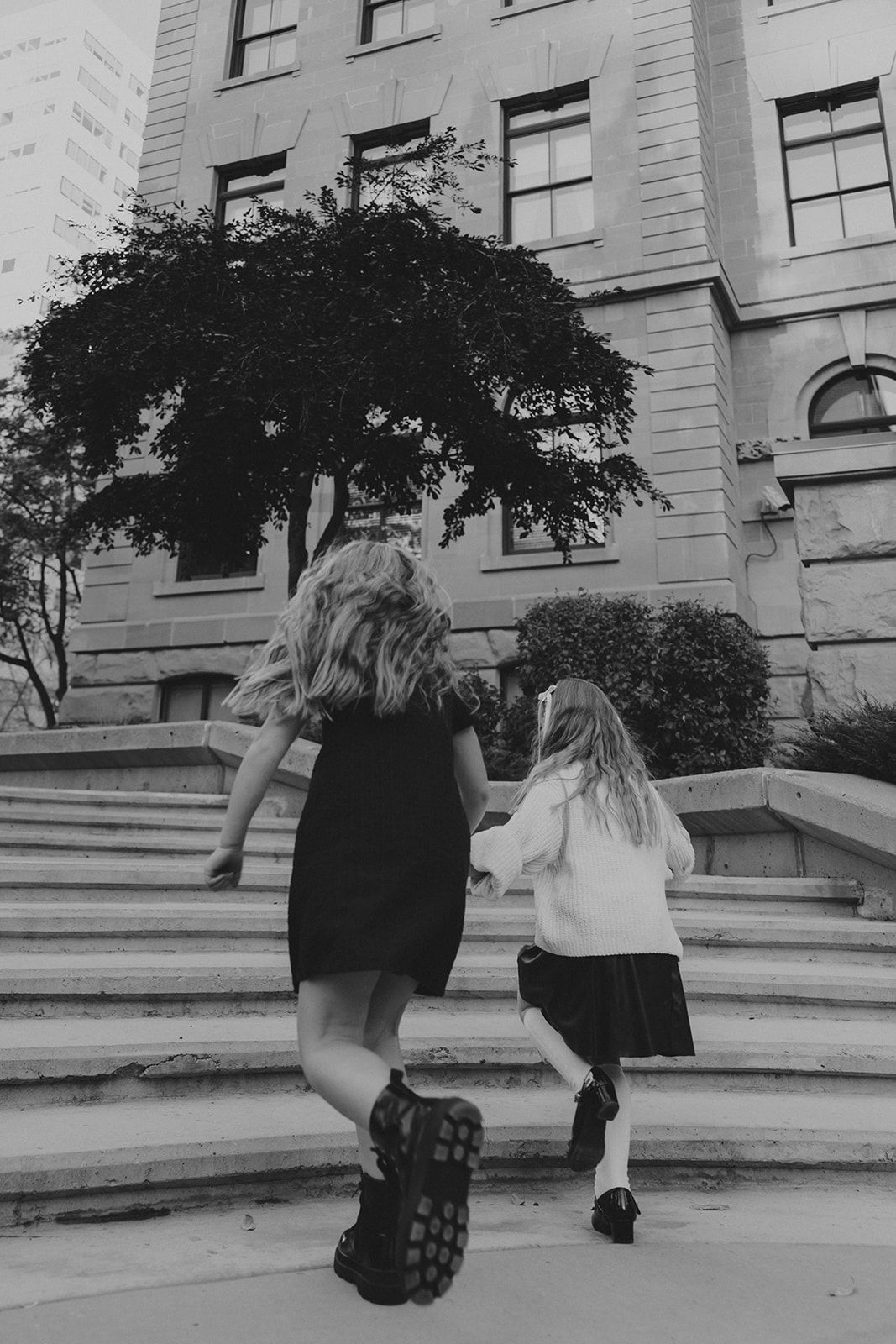 Black and white sequence of children running and jumping on stone steps.