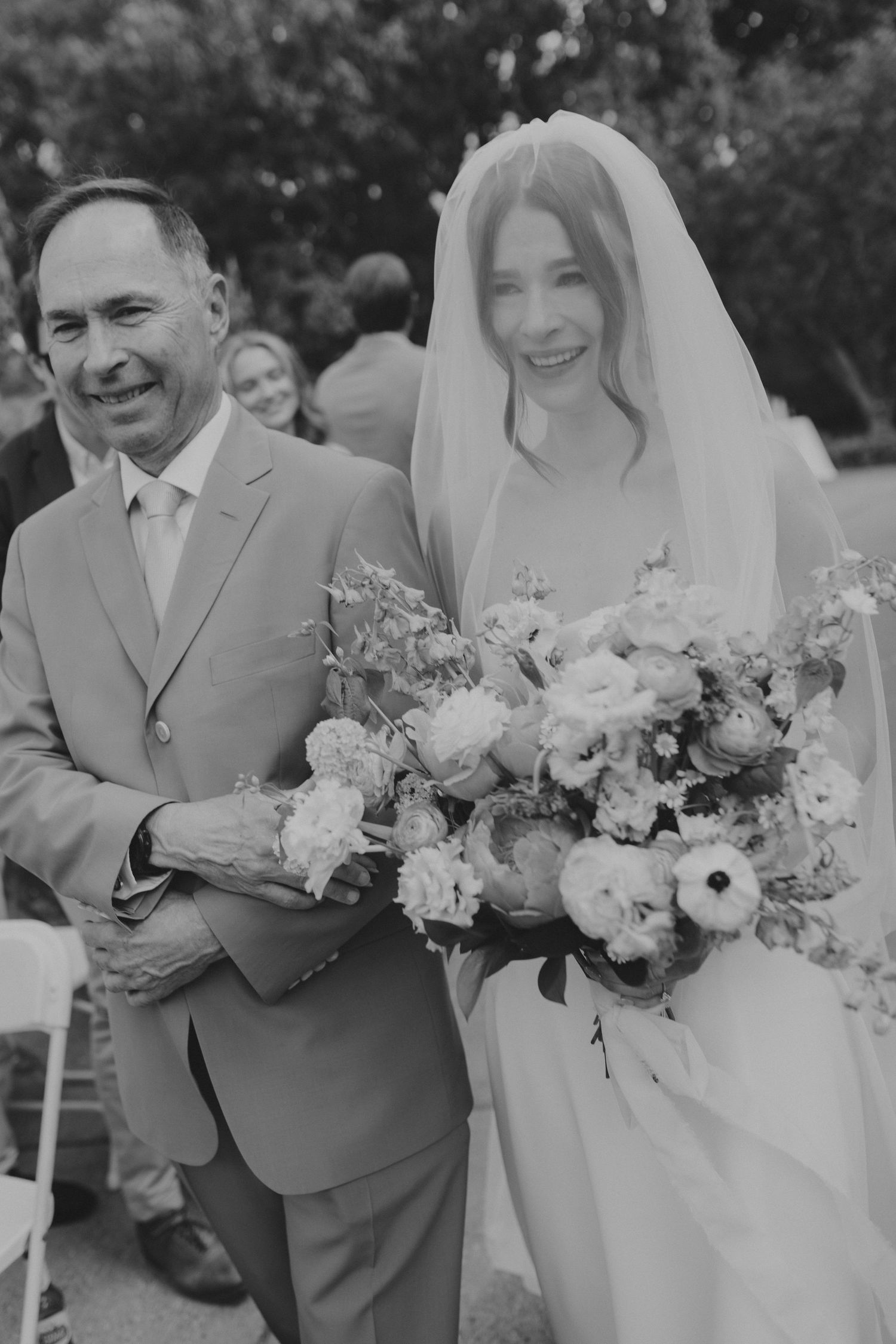 Wedding party holding beautiful pastel bouquets outdoors.
