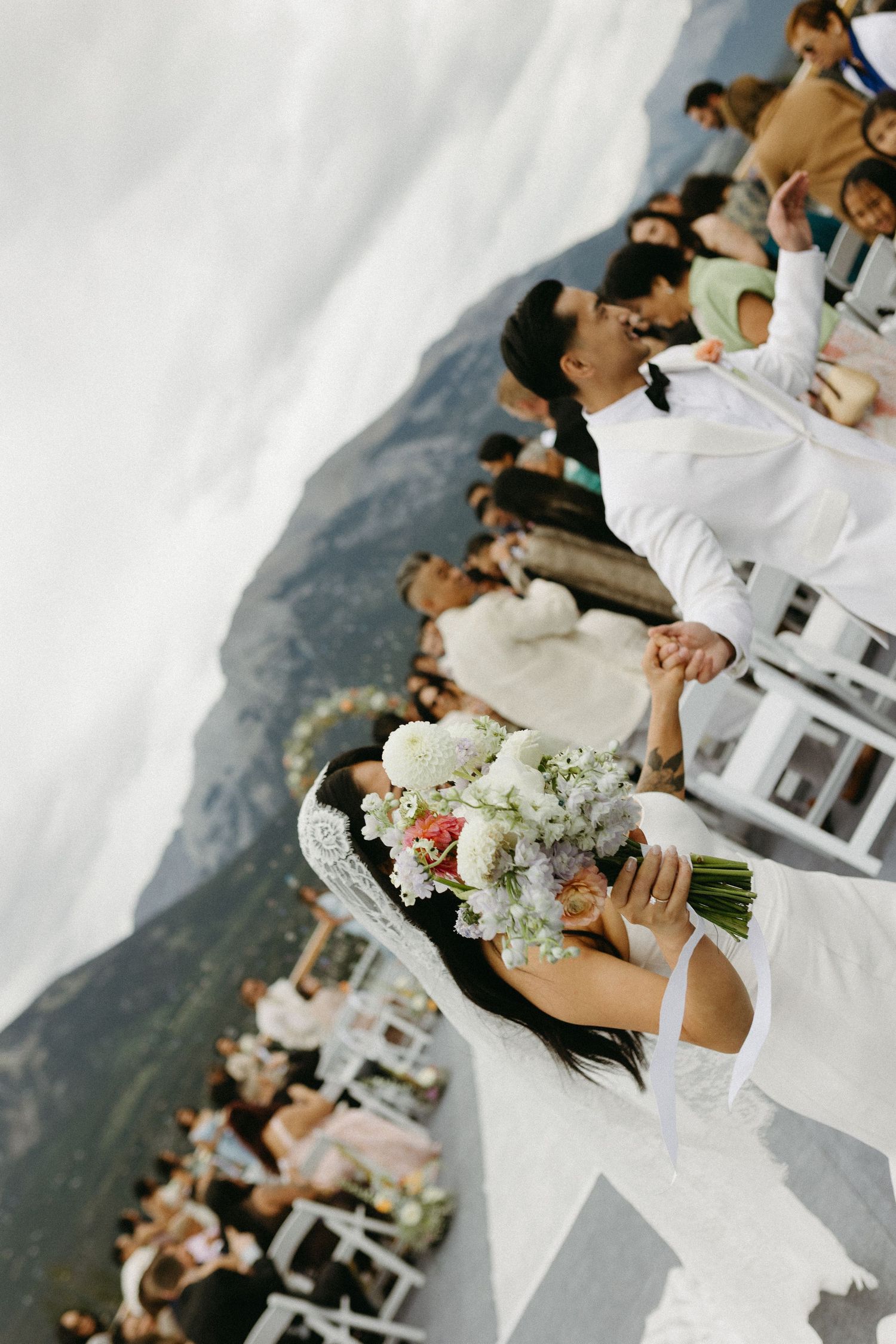 Wedding ceremony candid moments with mountain vista in background.