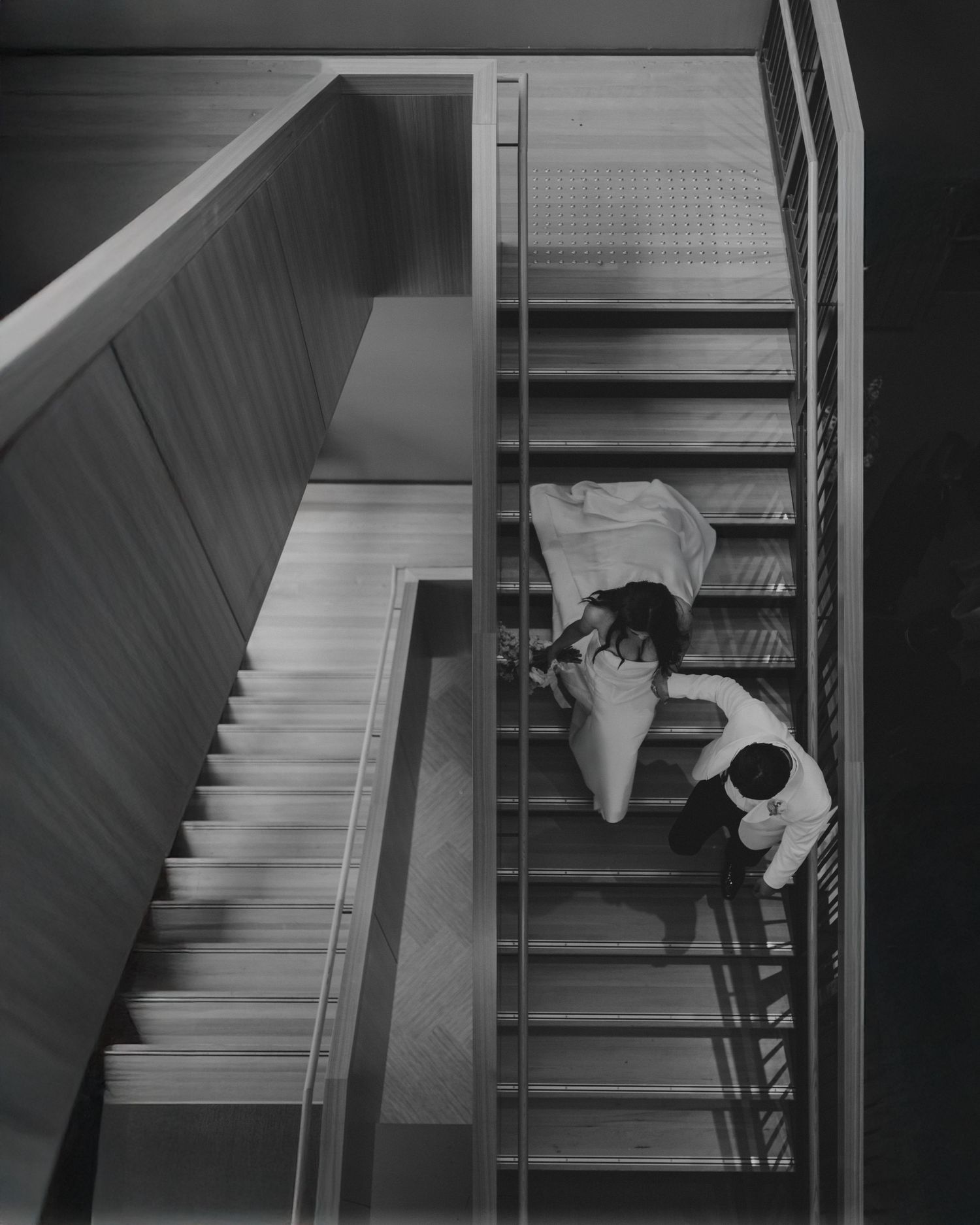 Artistic black and white photo of photographer shooting down stairwell.