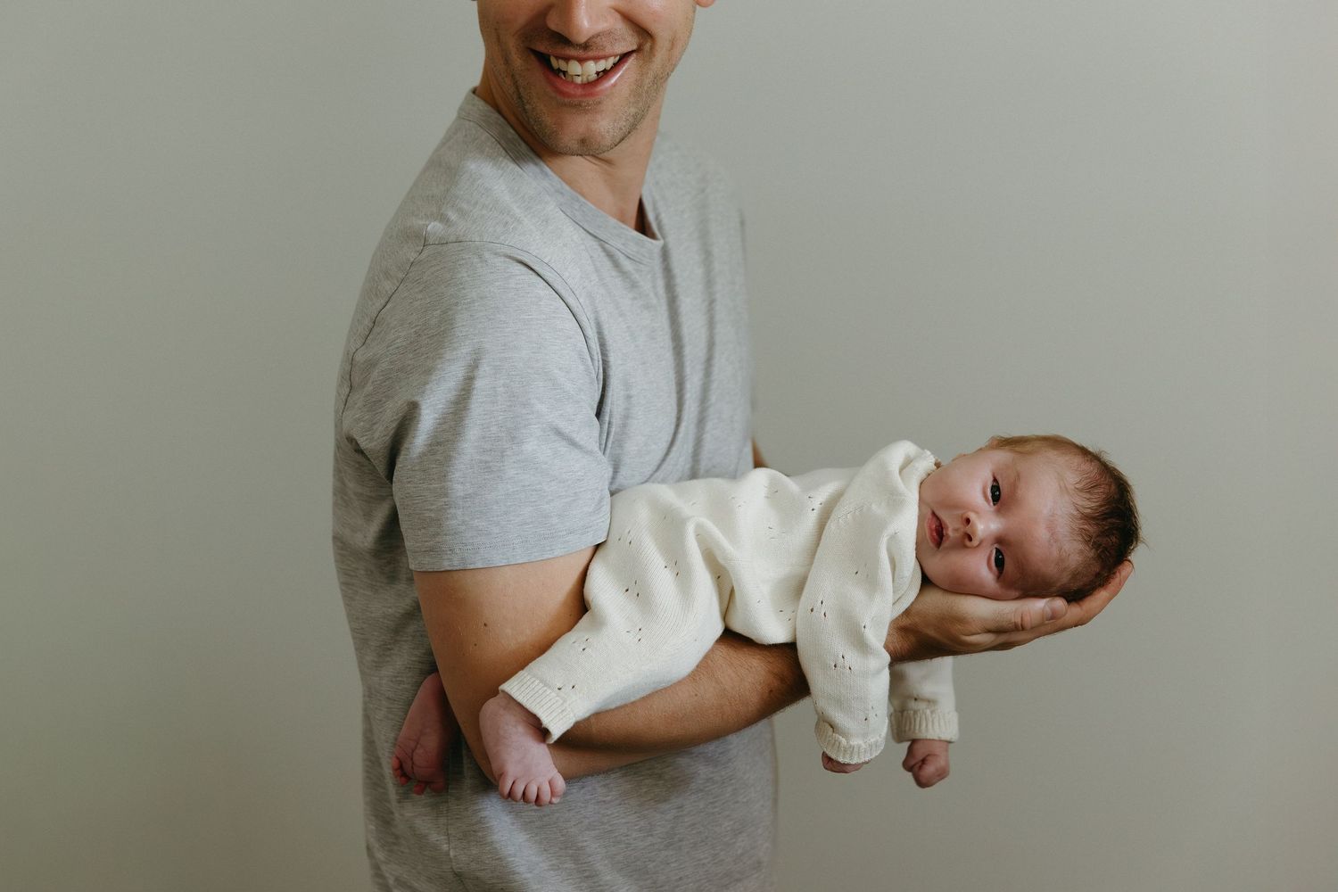 Series of photos showing a baby being held and cradled in playful positions.