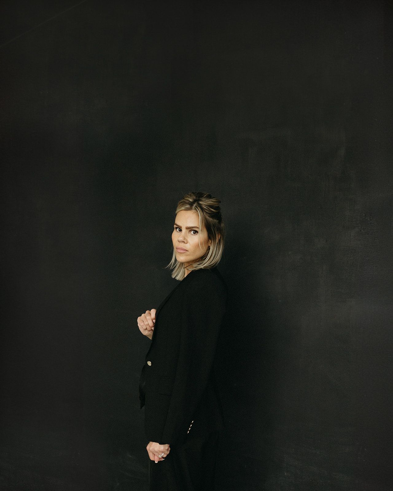 Dramatic portrait series against dark background showing contemplative poses.