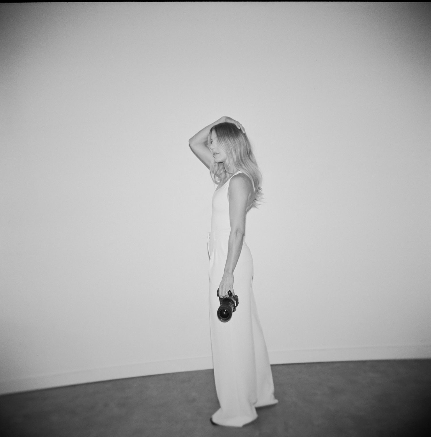 A series of black and white photographs showing a person in a white dress moving against a plain background.