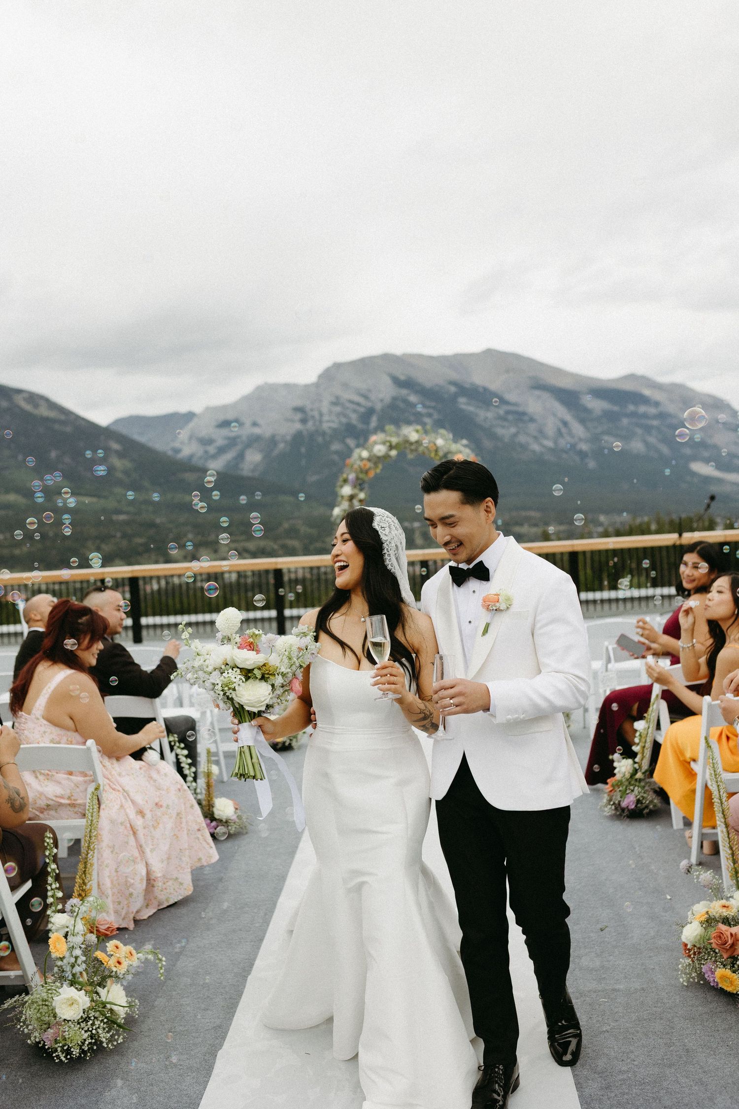 Wedding celebration on rooftop terrace with mountain range backdrop.