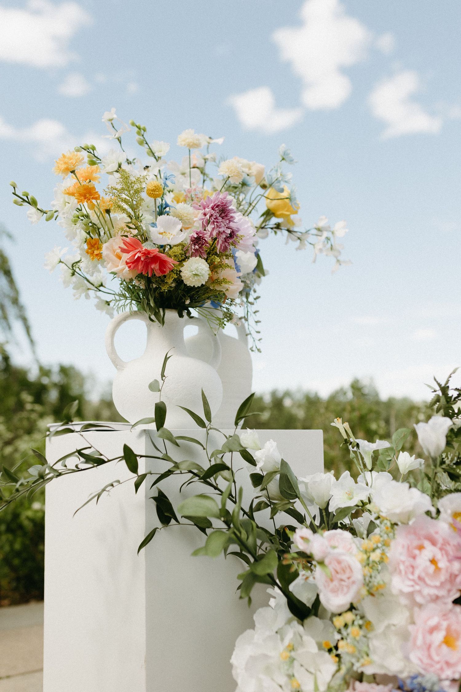 Elegant floral arrangements with white and pink blooms decorating a wedding venue.