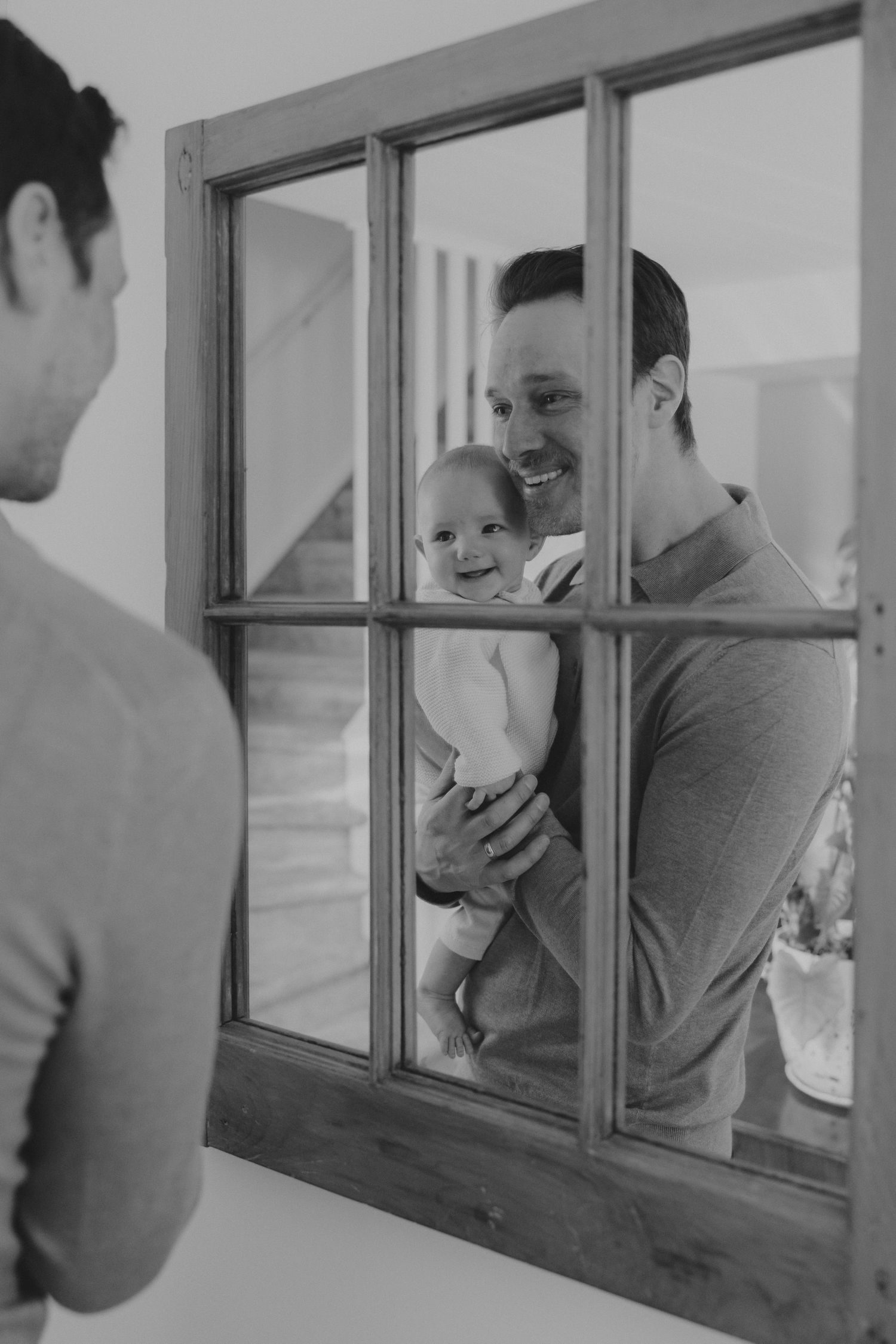 A series of playful interactions through a window pane in black and white.