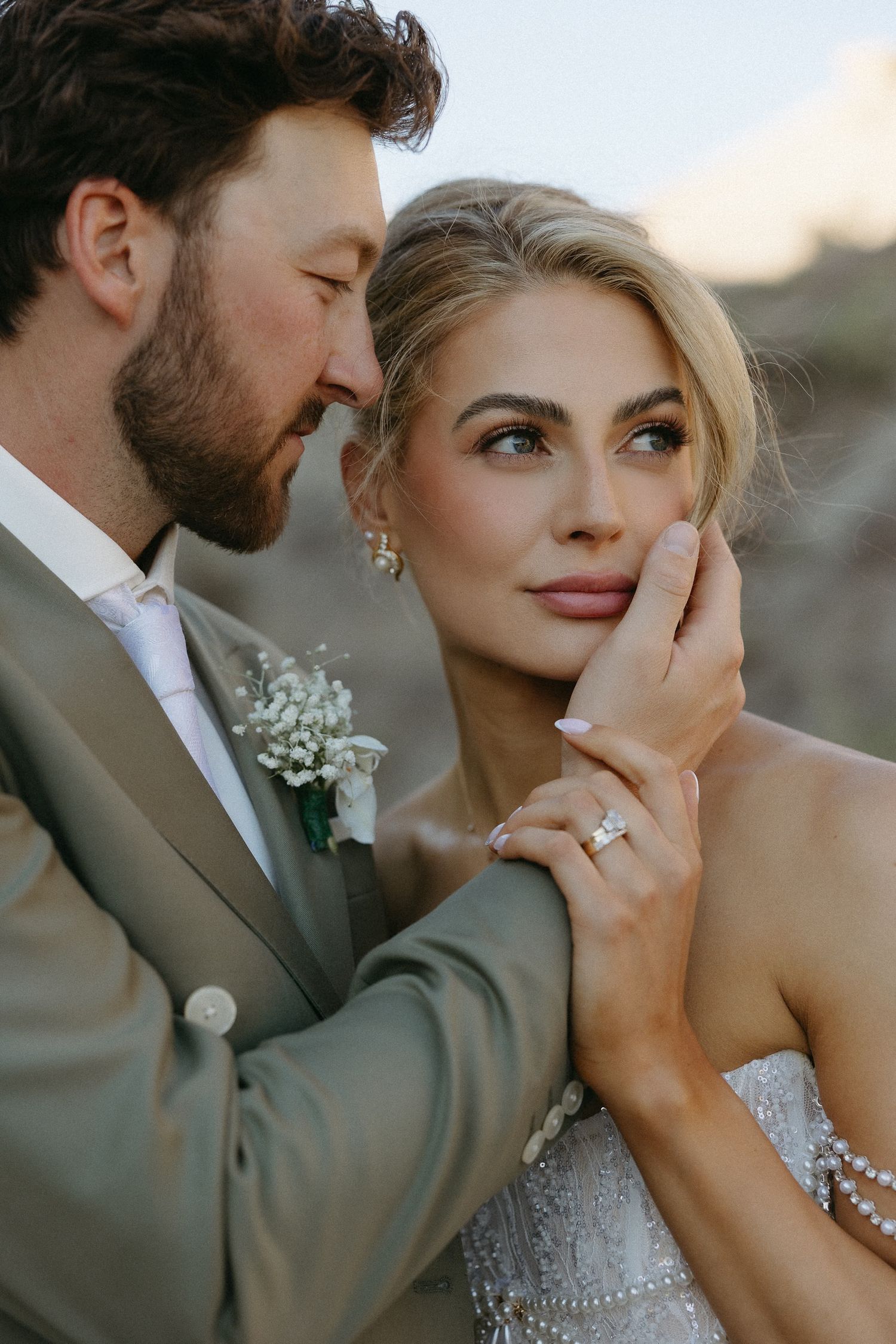 Intimate wedding couple portrait with baby's breath flowers and golden sunset lighting.