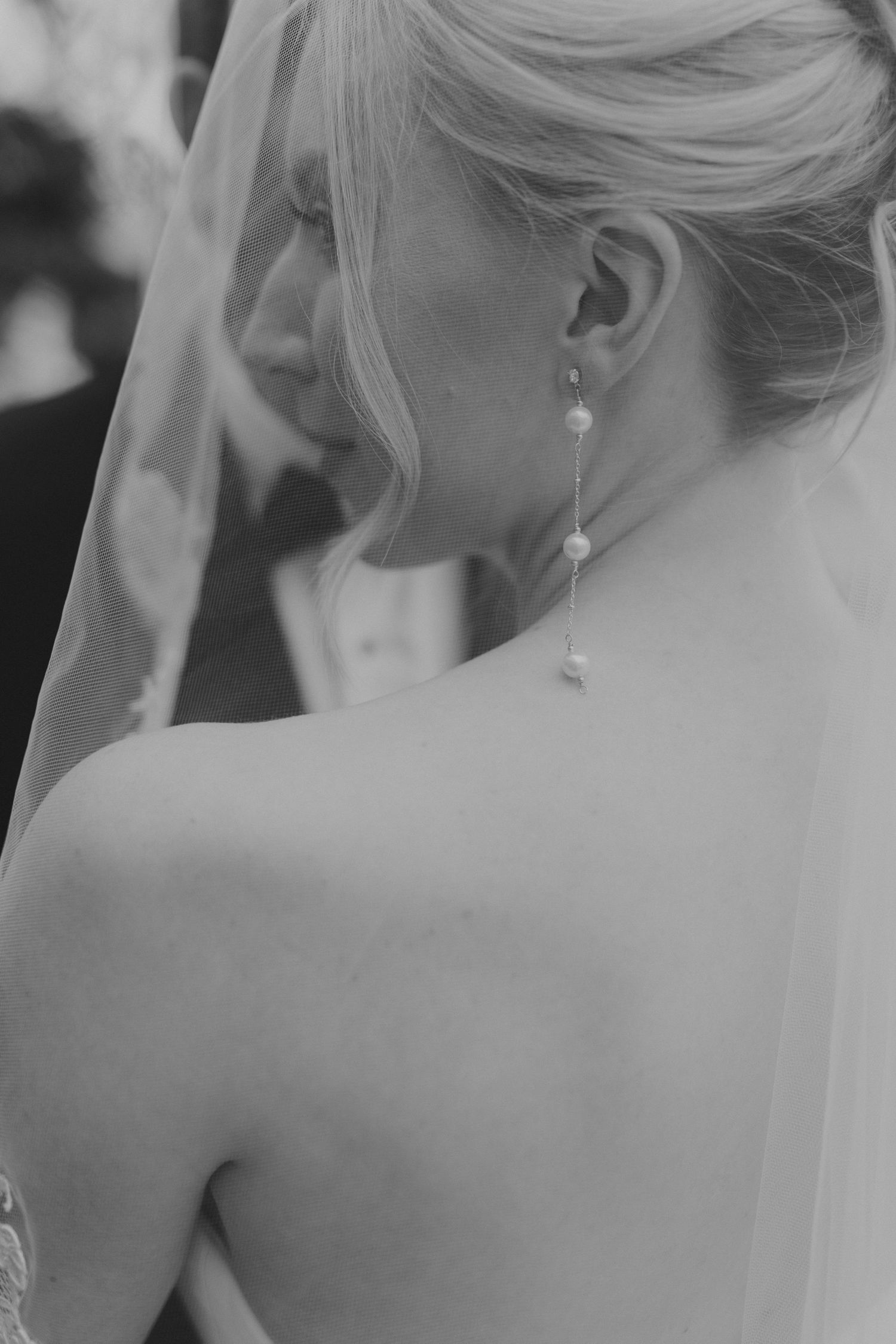 Close-up black and white detail of bridal hairstyle and veil.