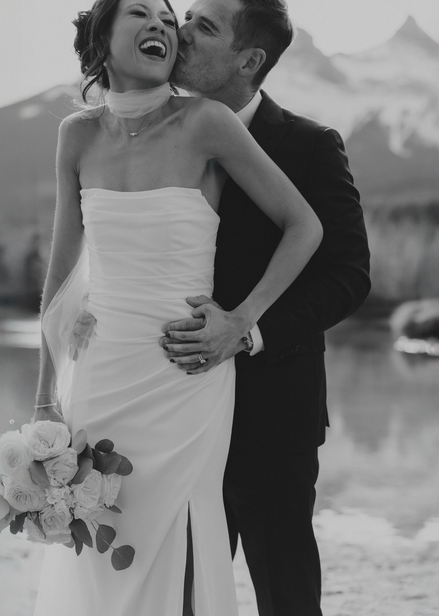 Candid black and white wedding portraits with mountain backdrop.