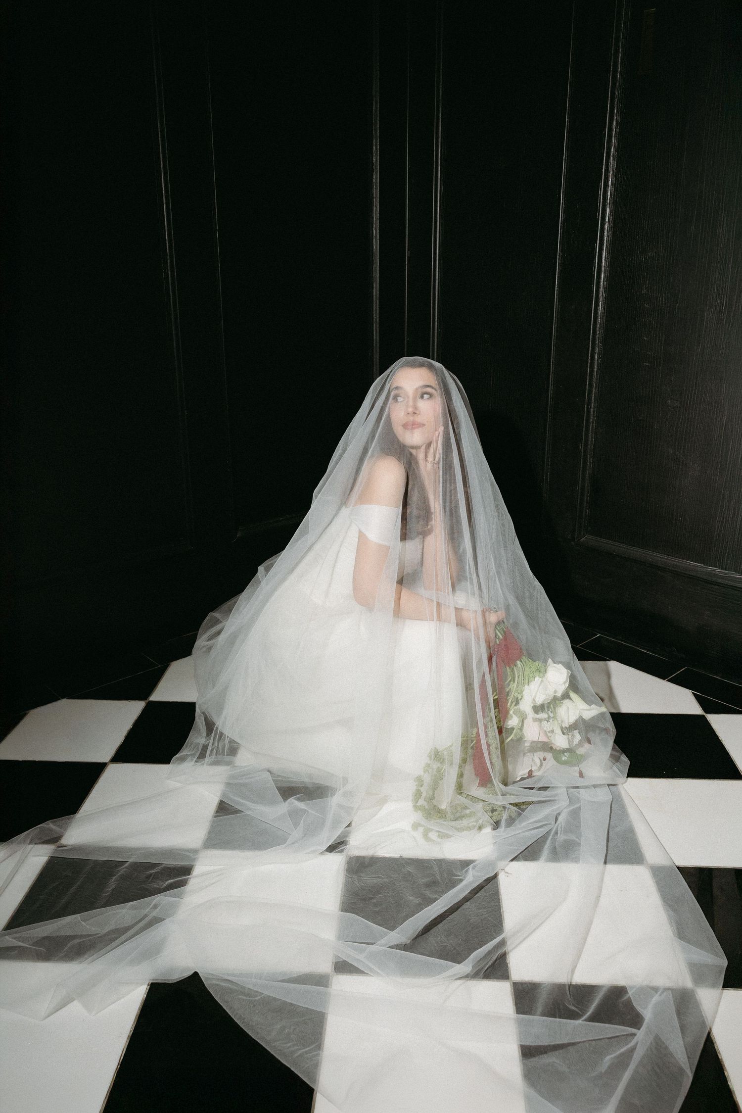 A series of progressive images showing a white bridal veil flowing and moving across a dark background.