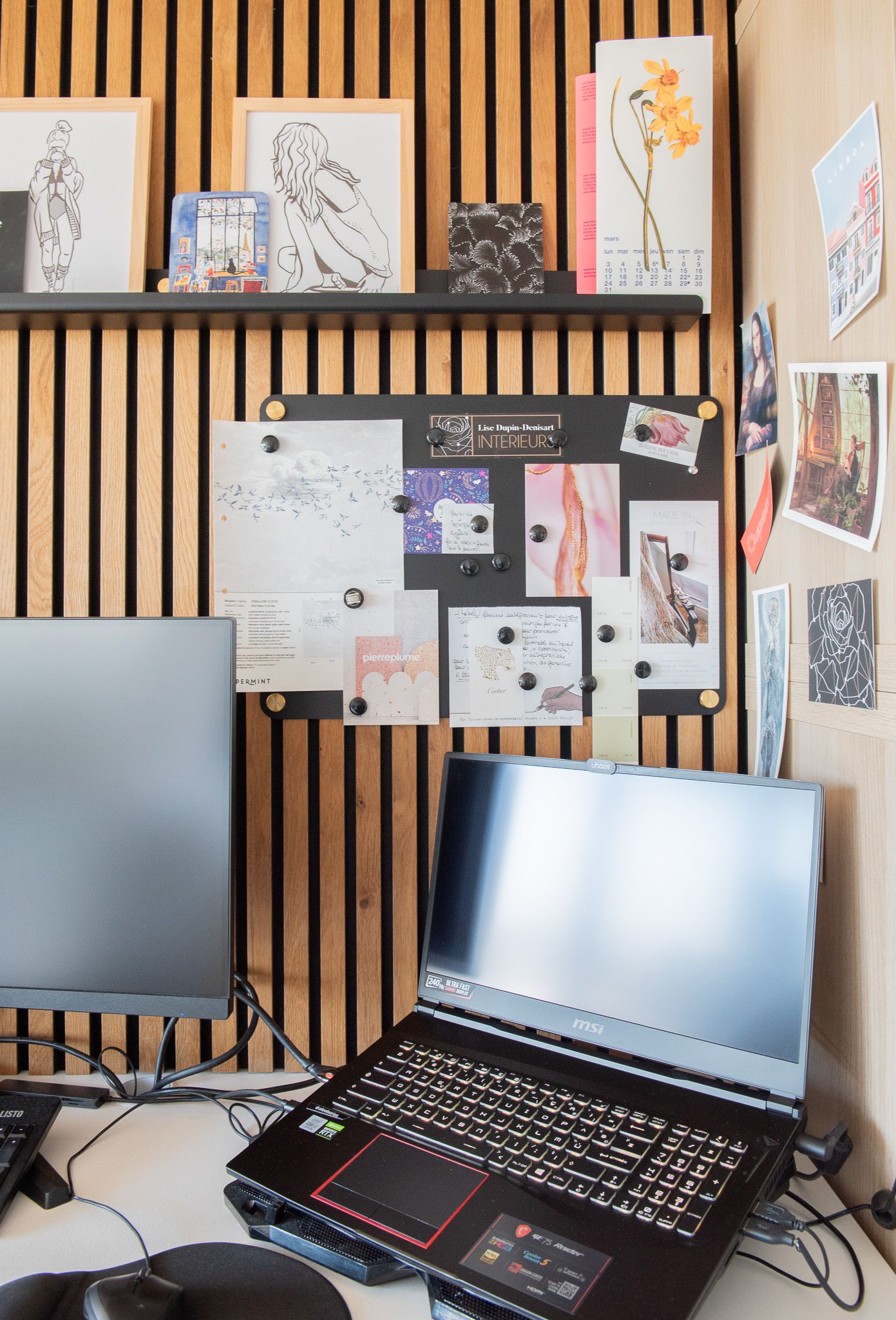 Espace de travail créatif avec ordinateur portable ASUS, tableau d'inspiration et croquis artistiques sur un mur en lattes de bois réalisé
