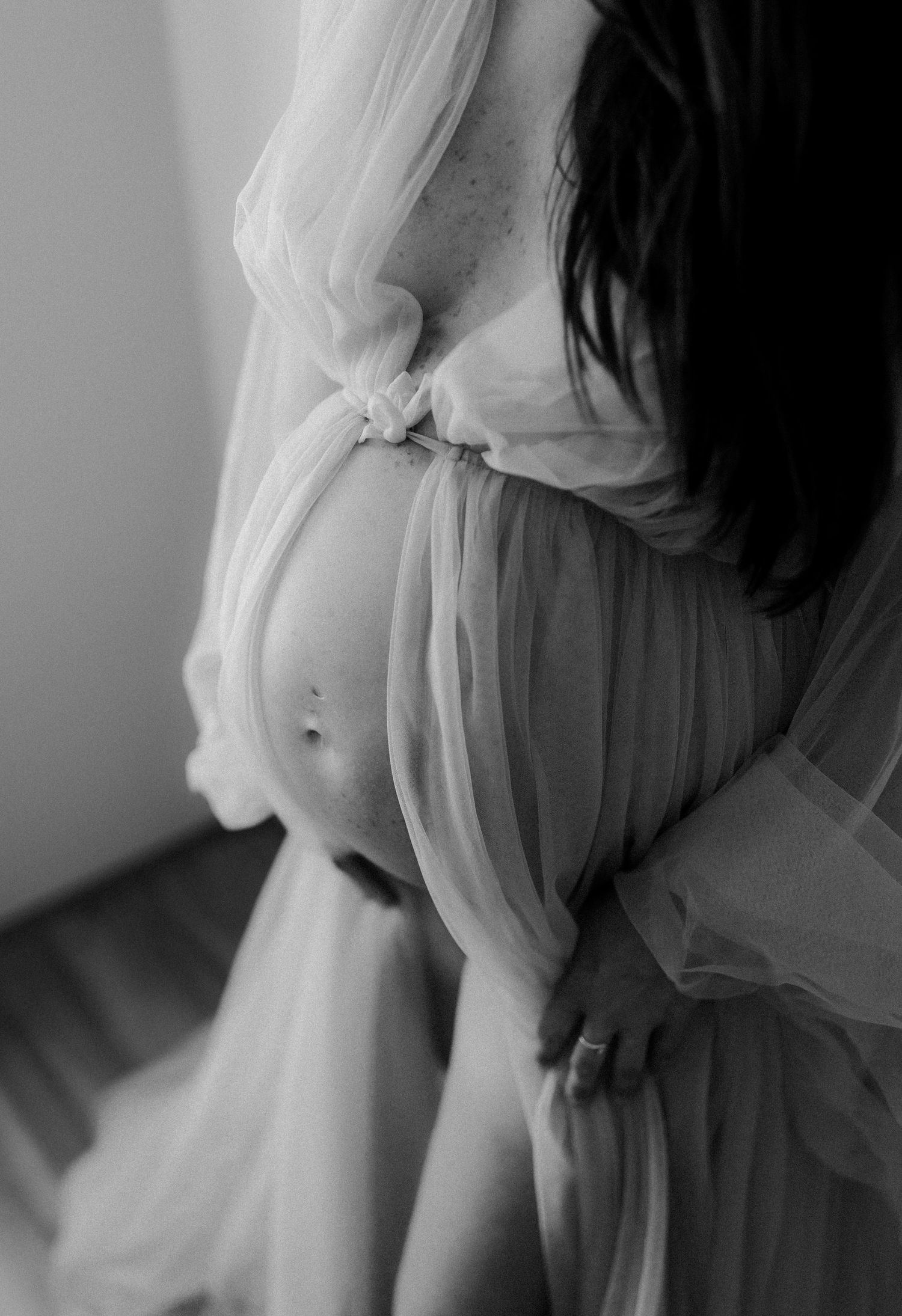 Pregnant mother wearing a flowing dress during an in home maternity session in Bunbury, Western Australia.