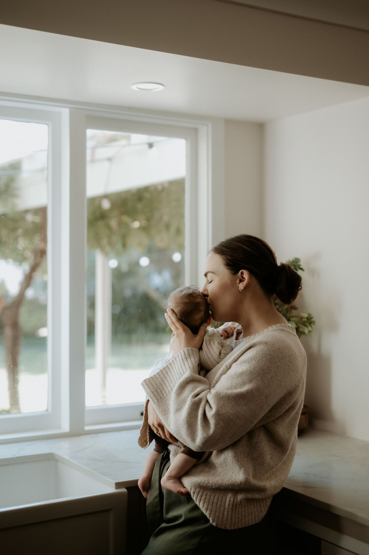 Mother holding her baby during a natural and relaxed in home session in Burekup, Western Australia.