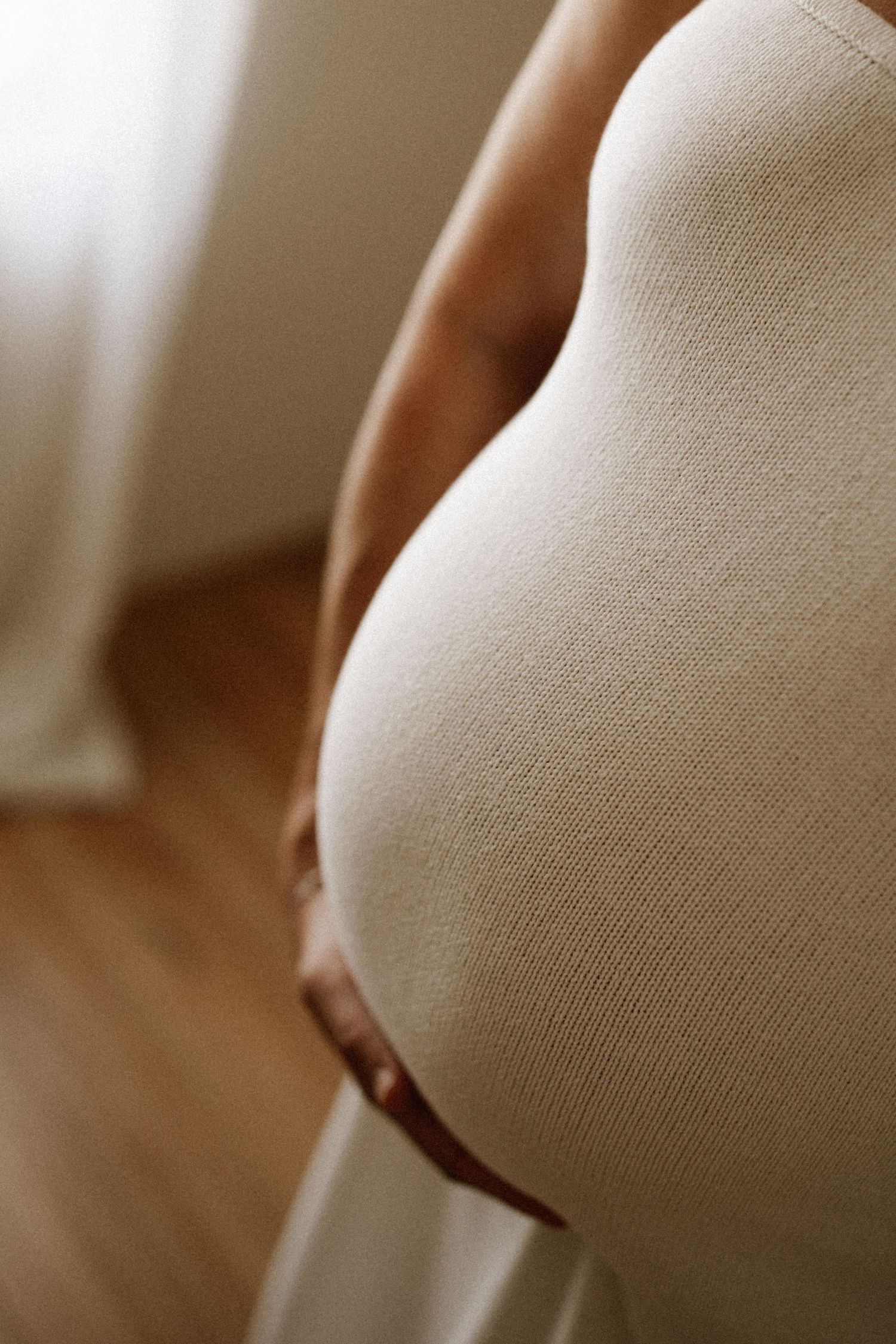 Pregnant mother wearing a knit dress during an in home maternity session in Bunbury, Western Australia.