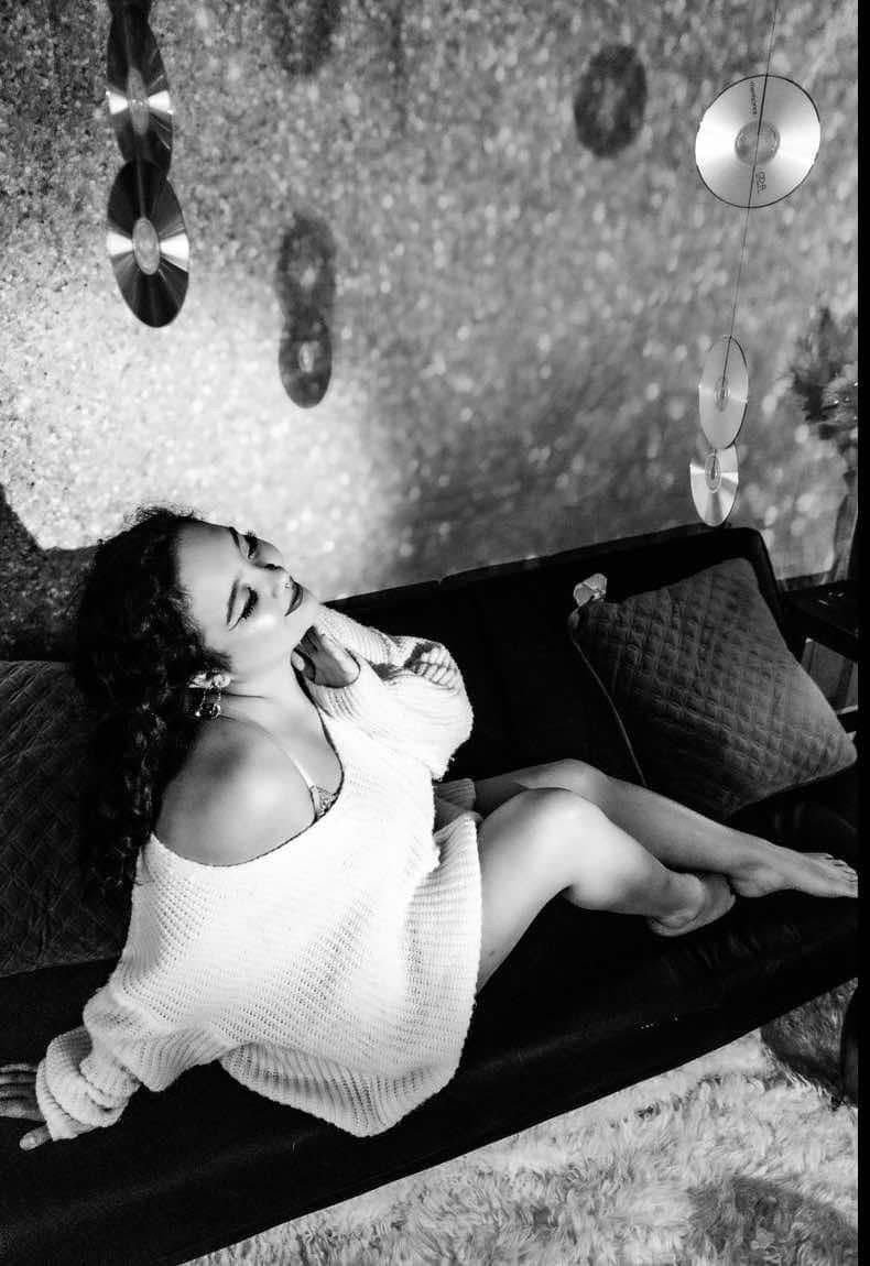 Black & White image of an Asian woman in an over sized sweater smiling in luxe. Boudoir portrait session Hinton Imagery in Jacksonville NC