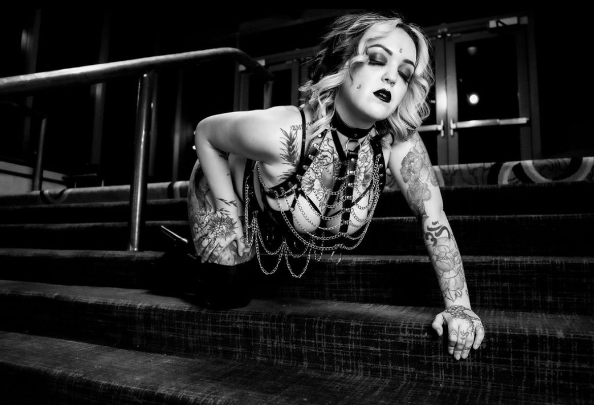 Black and White image of a Heavily tattooed White woman wearing a chain body jewelry Boudoir by Hinton Imagery.